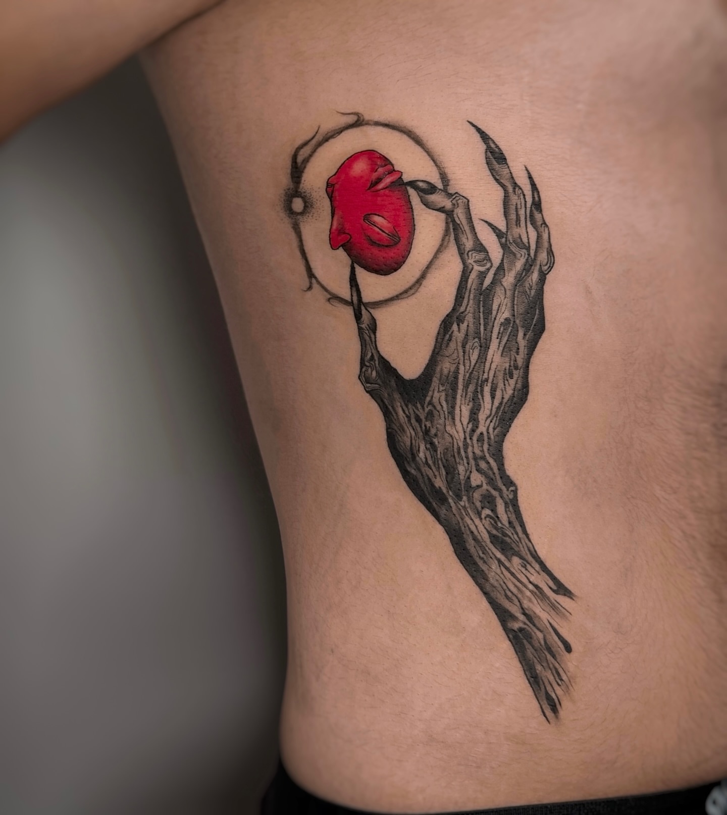 Red rose dark realism tattoo on the ribs by Lily K.