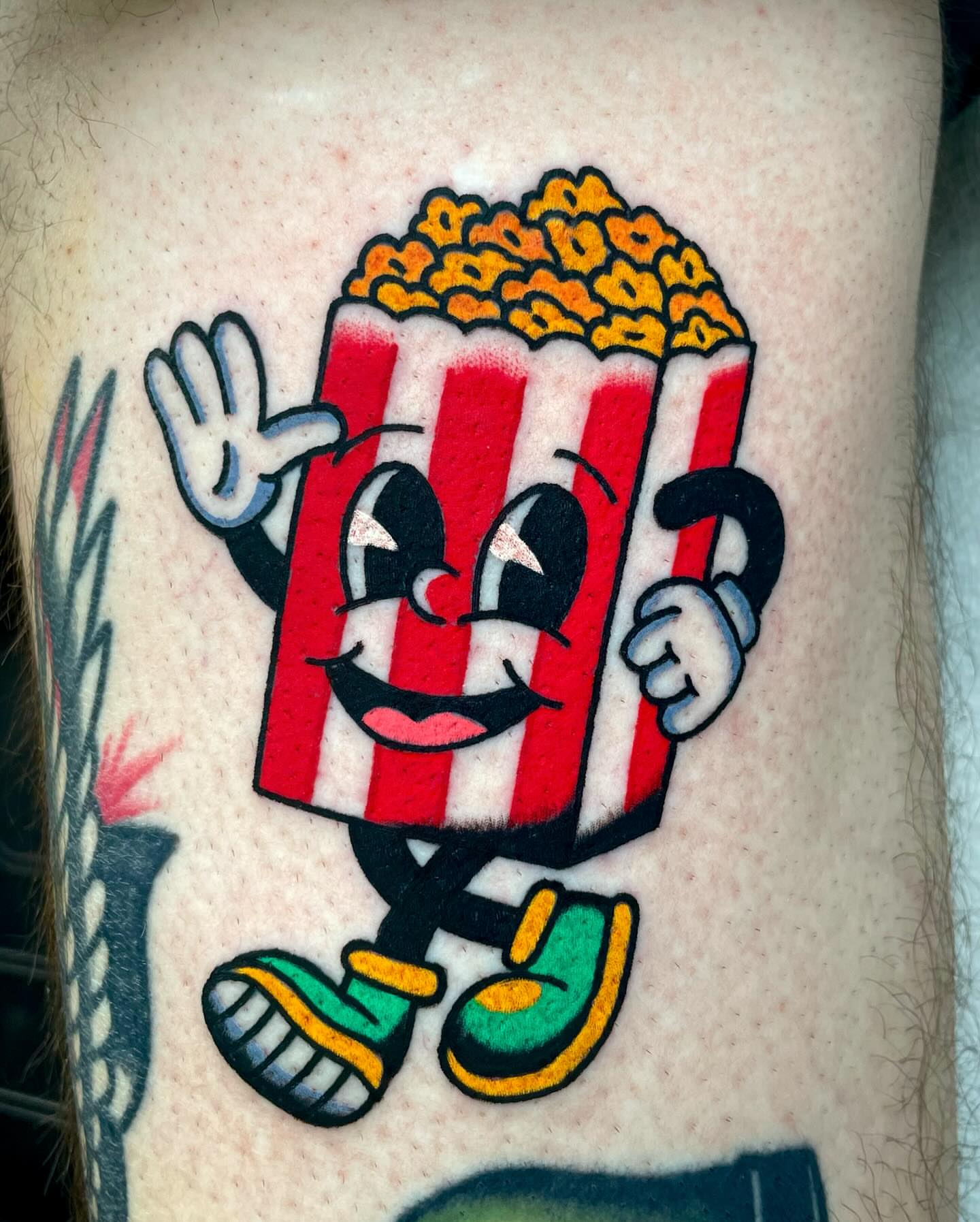 Popcorn character American traditional tattoo on the forearm by Ryan McDonald