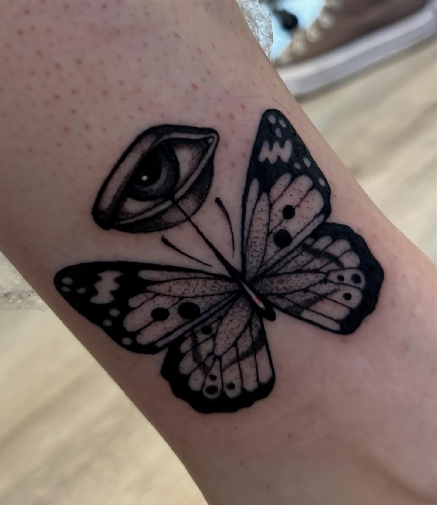 Butterfly and eye dotwork tattoo on the forearm by Tara, Exeter, Pennsylvania