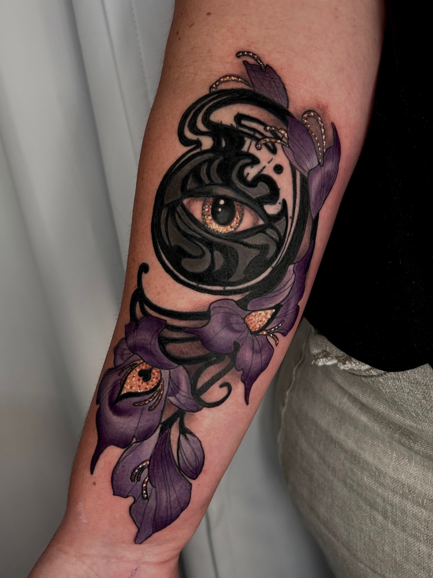 Eye and flowers neo-traditional tattoo on the forearm by Laura Babsie