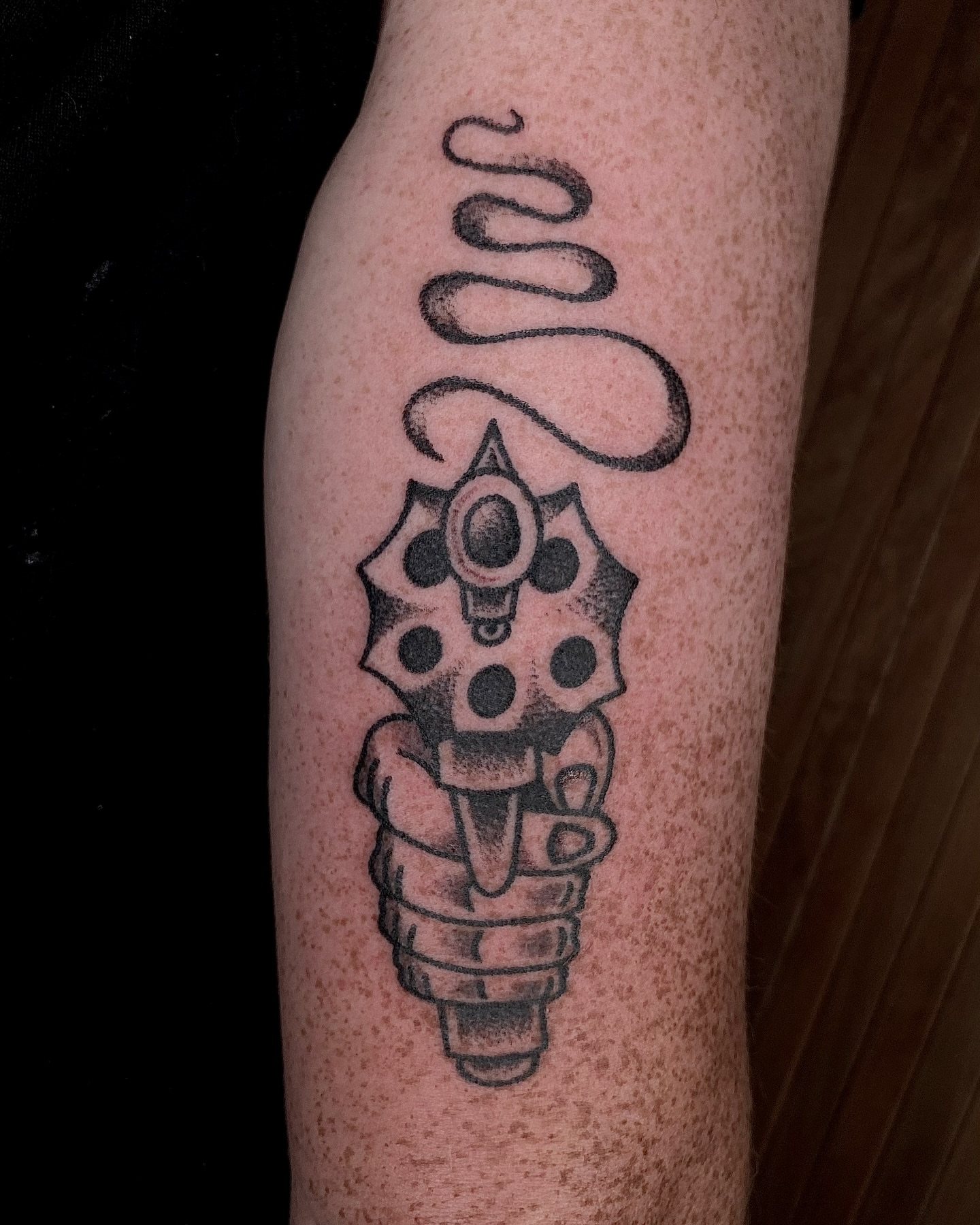 Gun and gear black and grey tattoo on the forearm by Daniel Diego