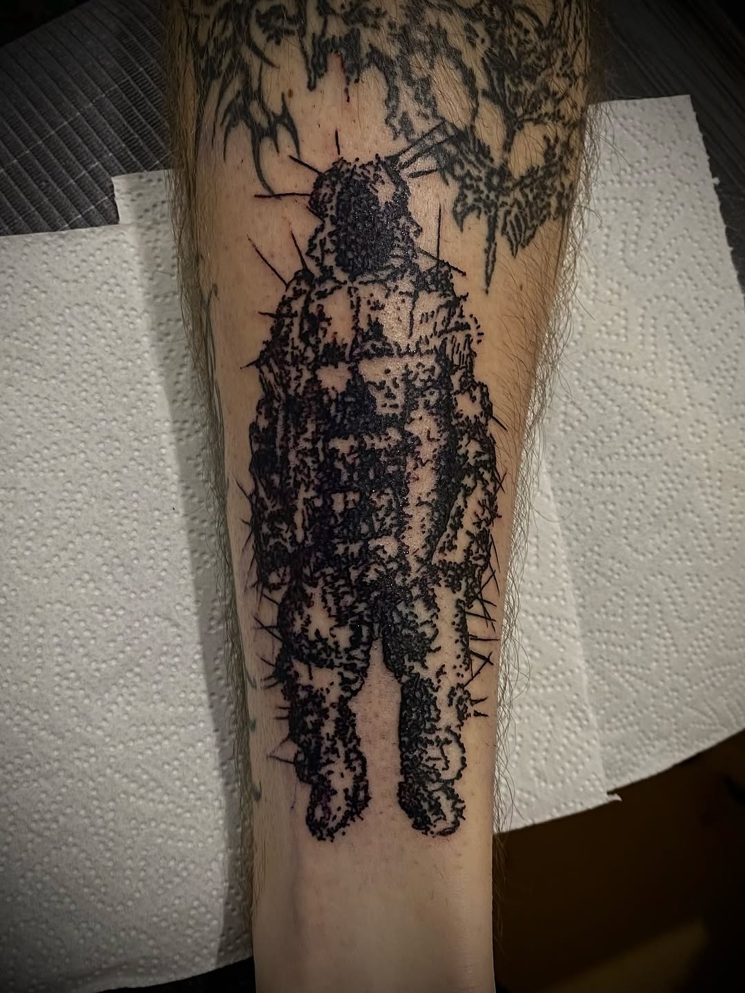 Figure with spikes blackwork tattoo on the forearm by John, Kyiv, Ukraine
