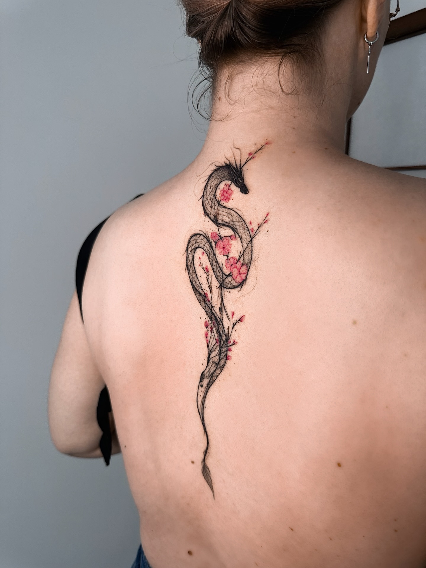 Snake and blossoms realism tattoo on the back by Mila, Riga, Latvia