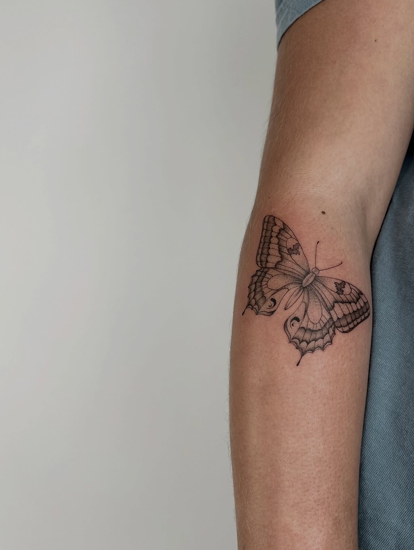 Butterfly black and grey tattoo on the forearm by Kennedy Ramey