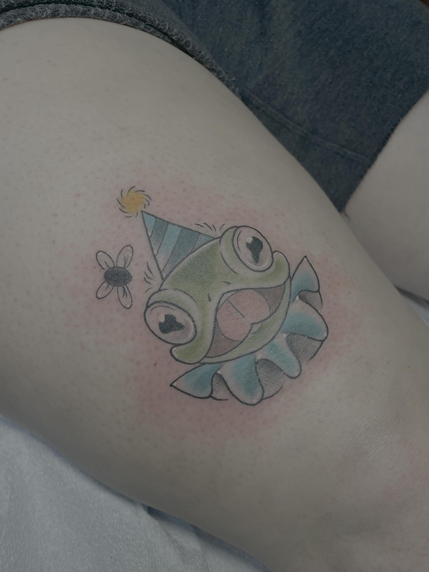 Fish with party hat new school tattoo on the thigh by Stevie Timmreck, Utica, Michigan