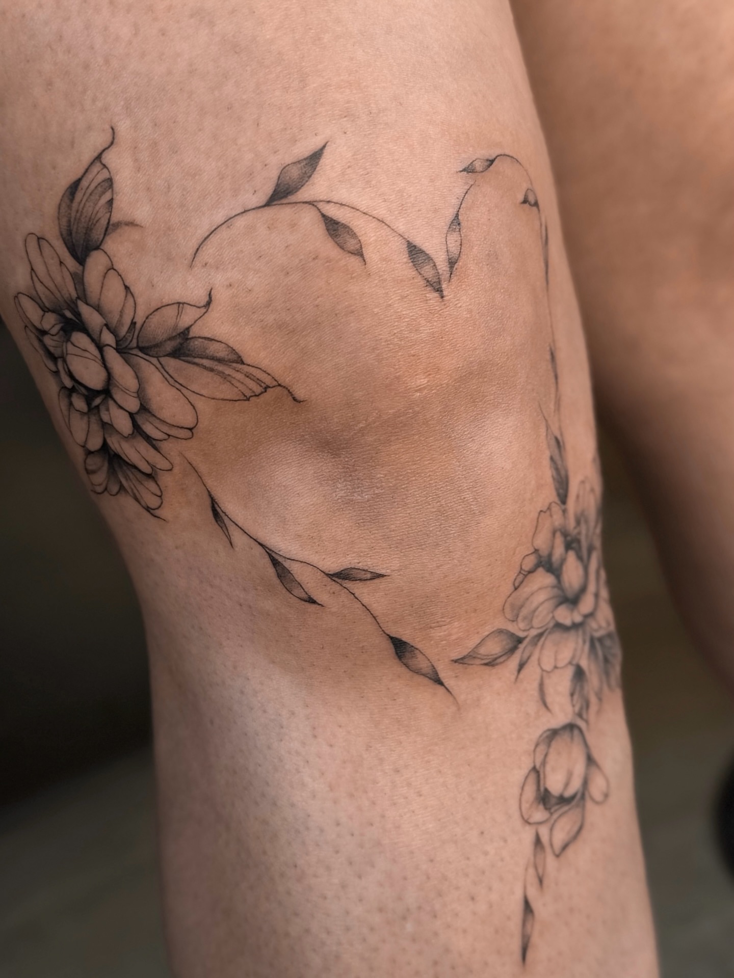 Floral arrangement black and grey tattoo on the thigh by Lily K.