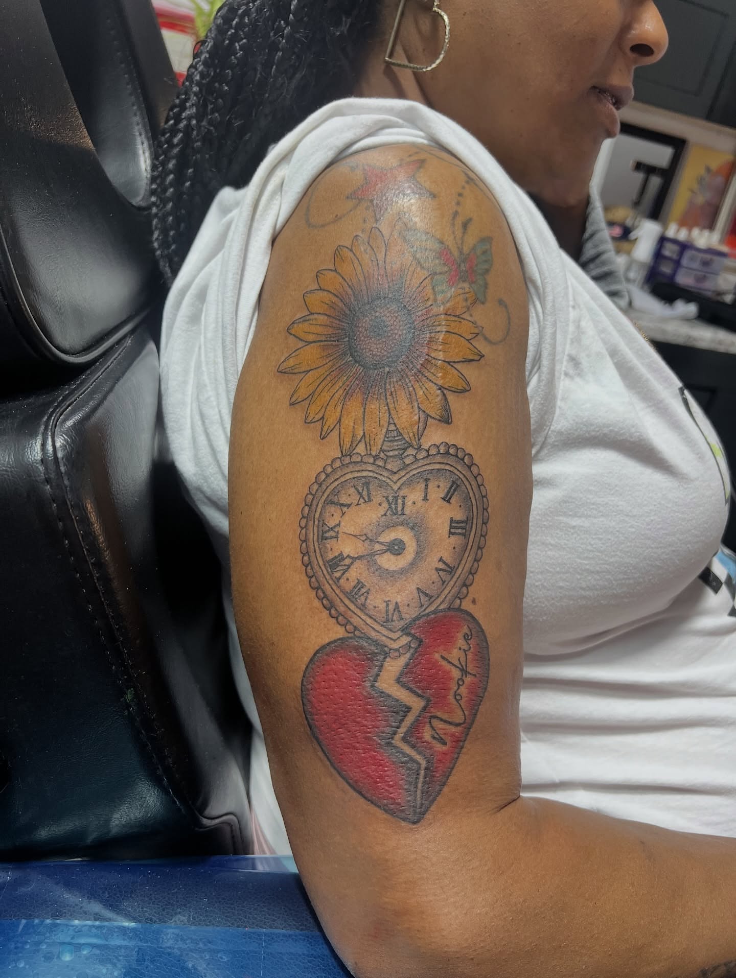 Broken heart clock American traditional tattoo on the upper arm by CandiCoatedInk