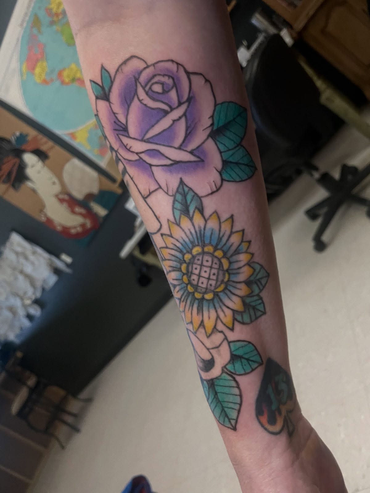 Rose and sunflower American traditional tattoo on the forearm by Logan Casimir