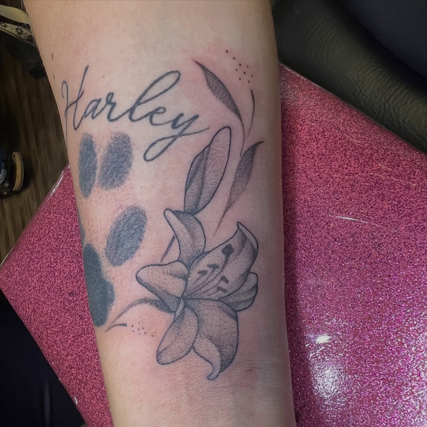 Lily and paw prints dotwork tattoo on the forearm by Dani McBay