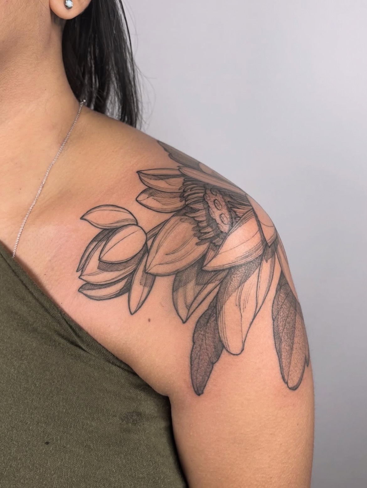 Lotus flower black and grey tattoo on the shoulder by Carol Jacky