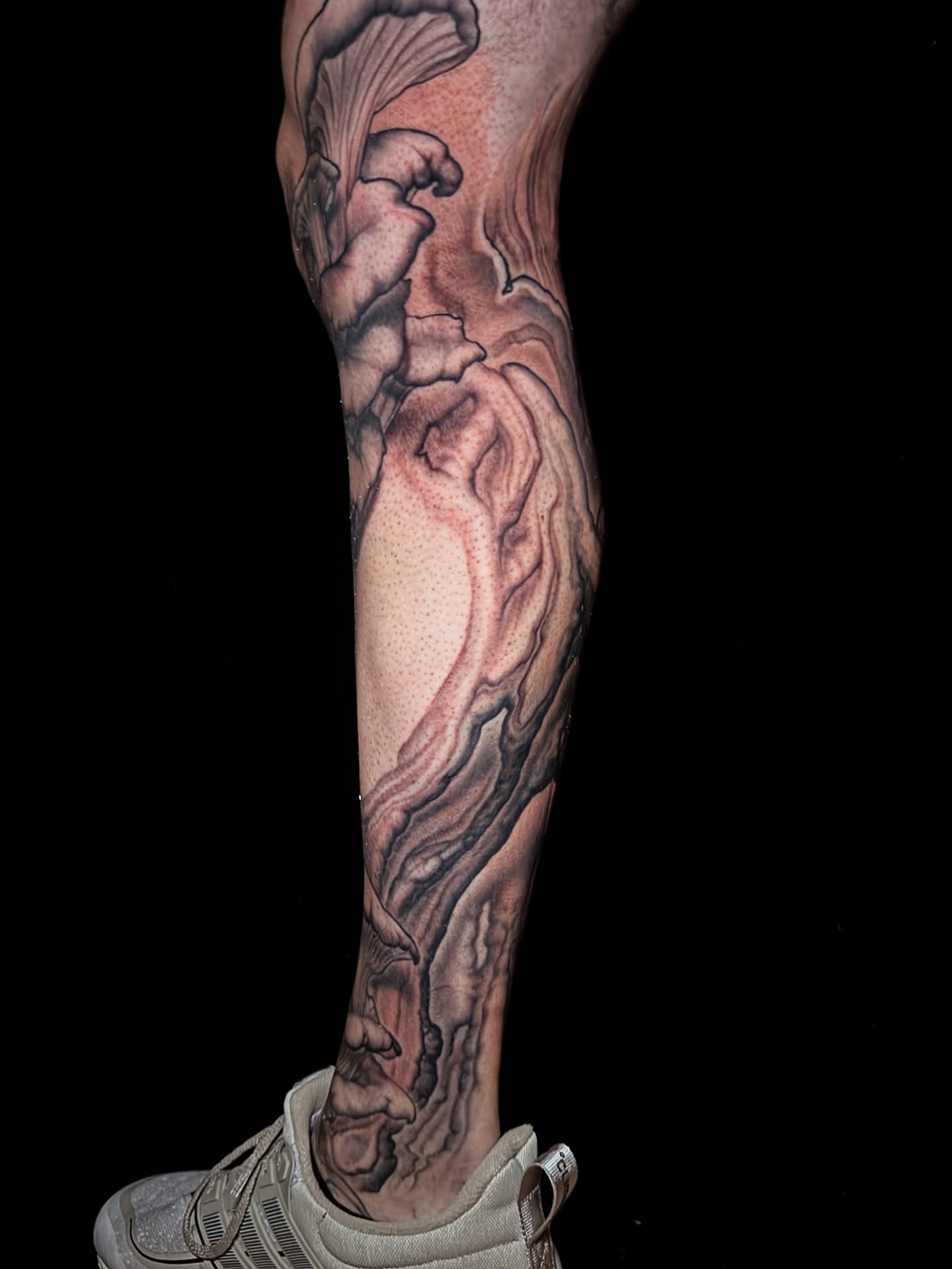 Abstract fluid realism tattoo on the calf by Jake Kirk