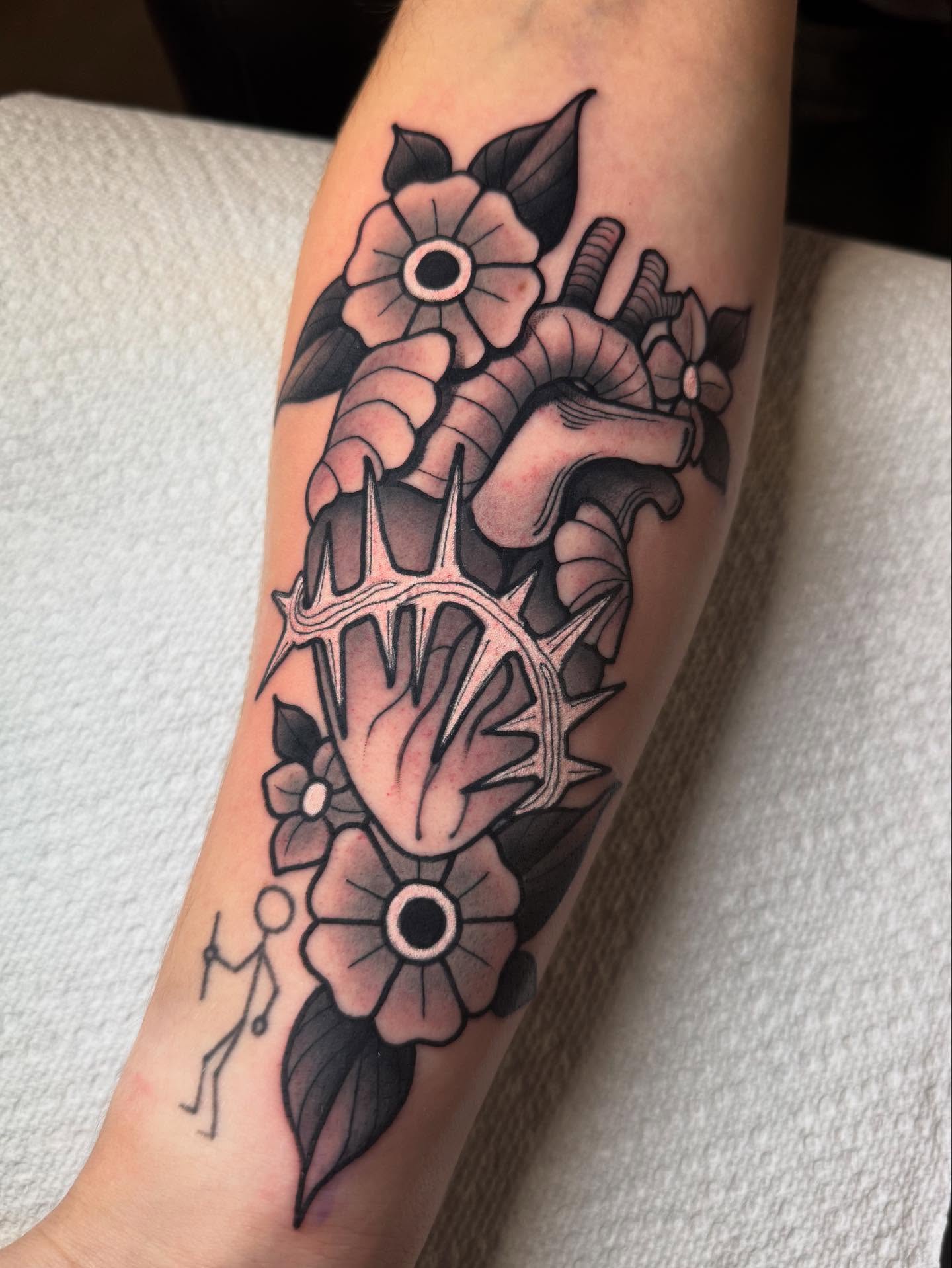 Anatomical heart with flowers American traditional tattoo on the forearm by Jess Longfield, Des Moines, Iowa