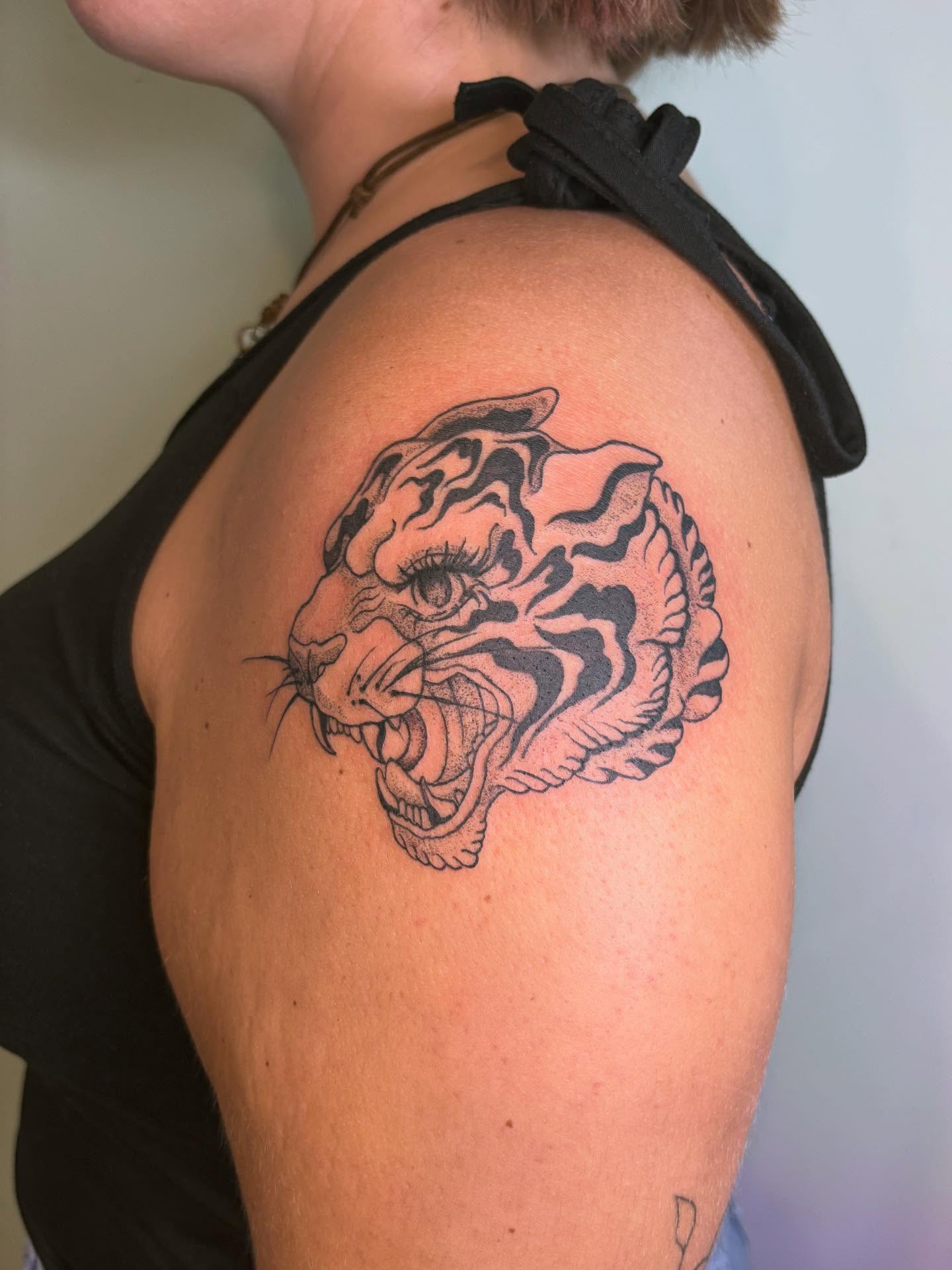 Tiger head black and grey tattoo on the shoulder by Ashley Ellerman
