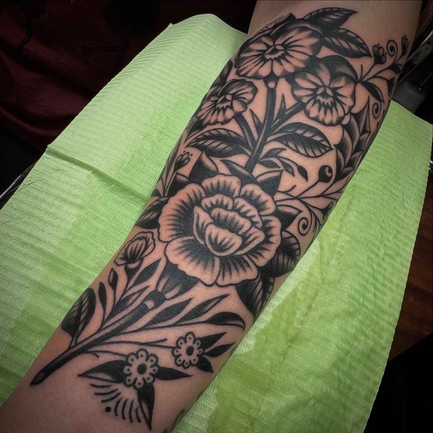 Floral bouquet black and grey tattoo on the forearm by Rogelio Robles
