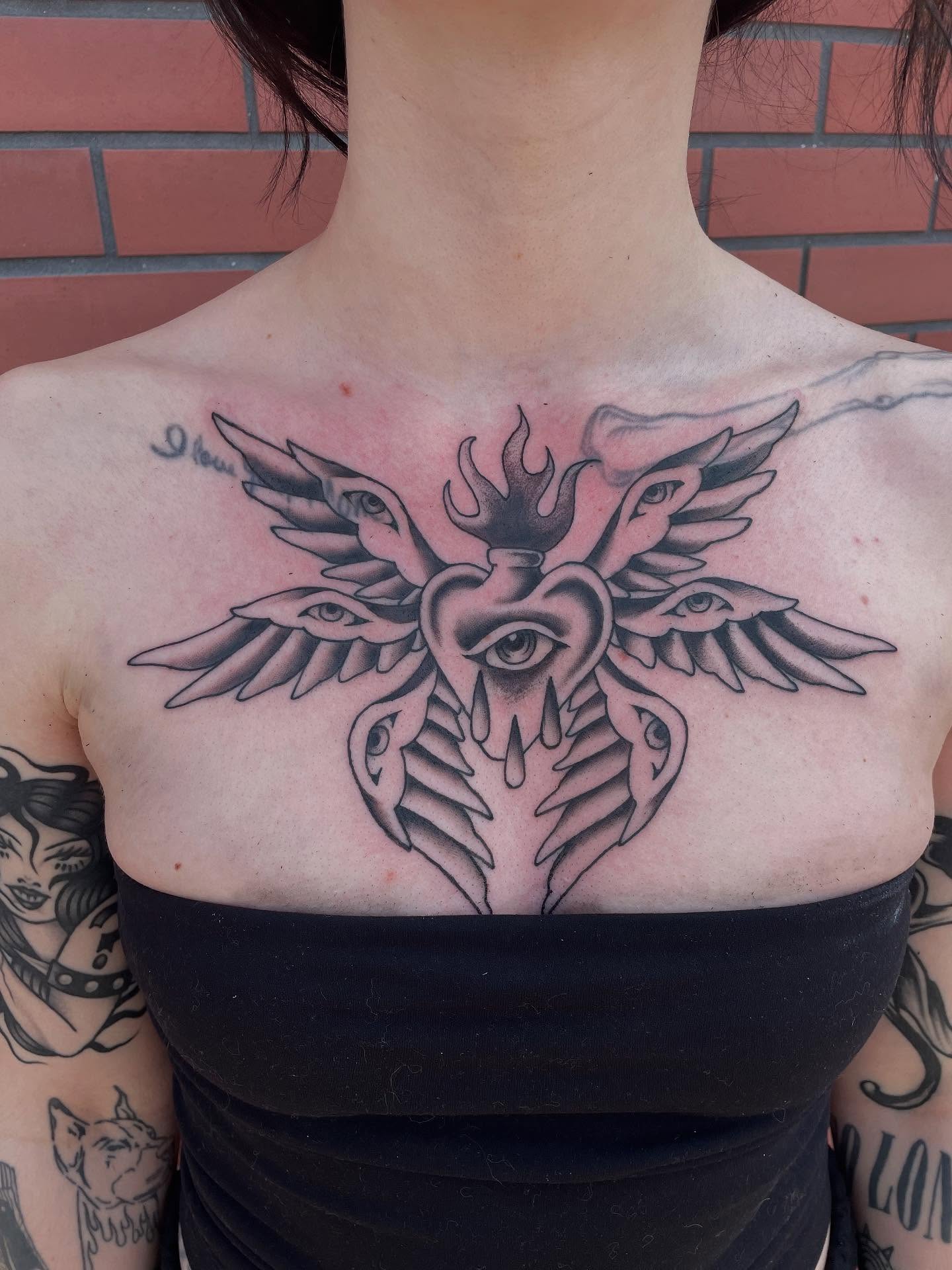 Heart with wings black and grey tattoo on the chest by Fionna Fanning