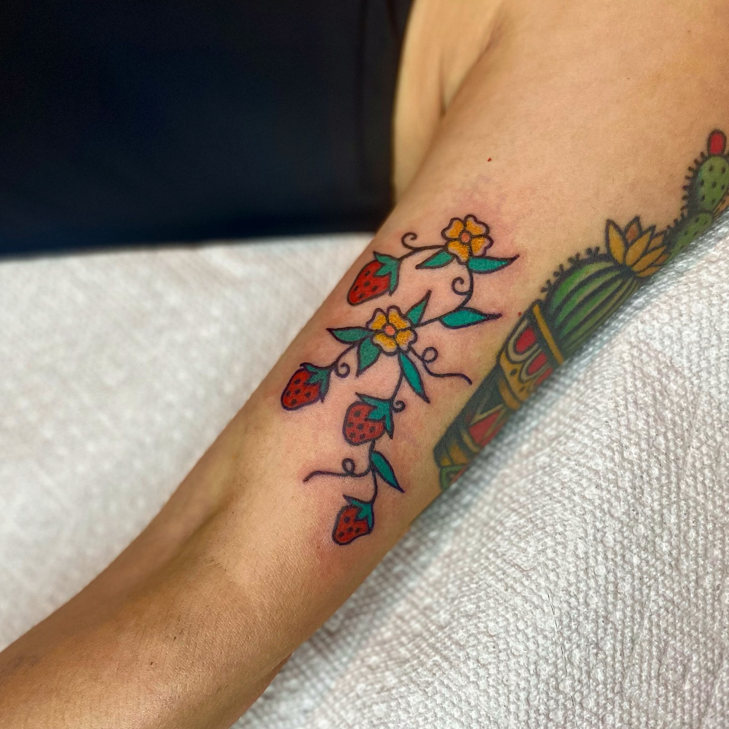 Strawberries and flowers American traditional tattoo on the forearm by Myka King