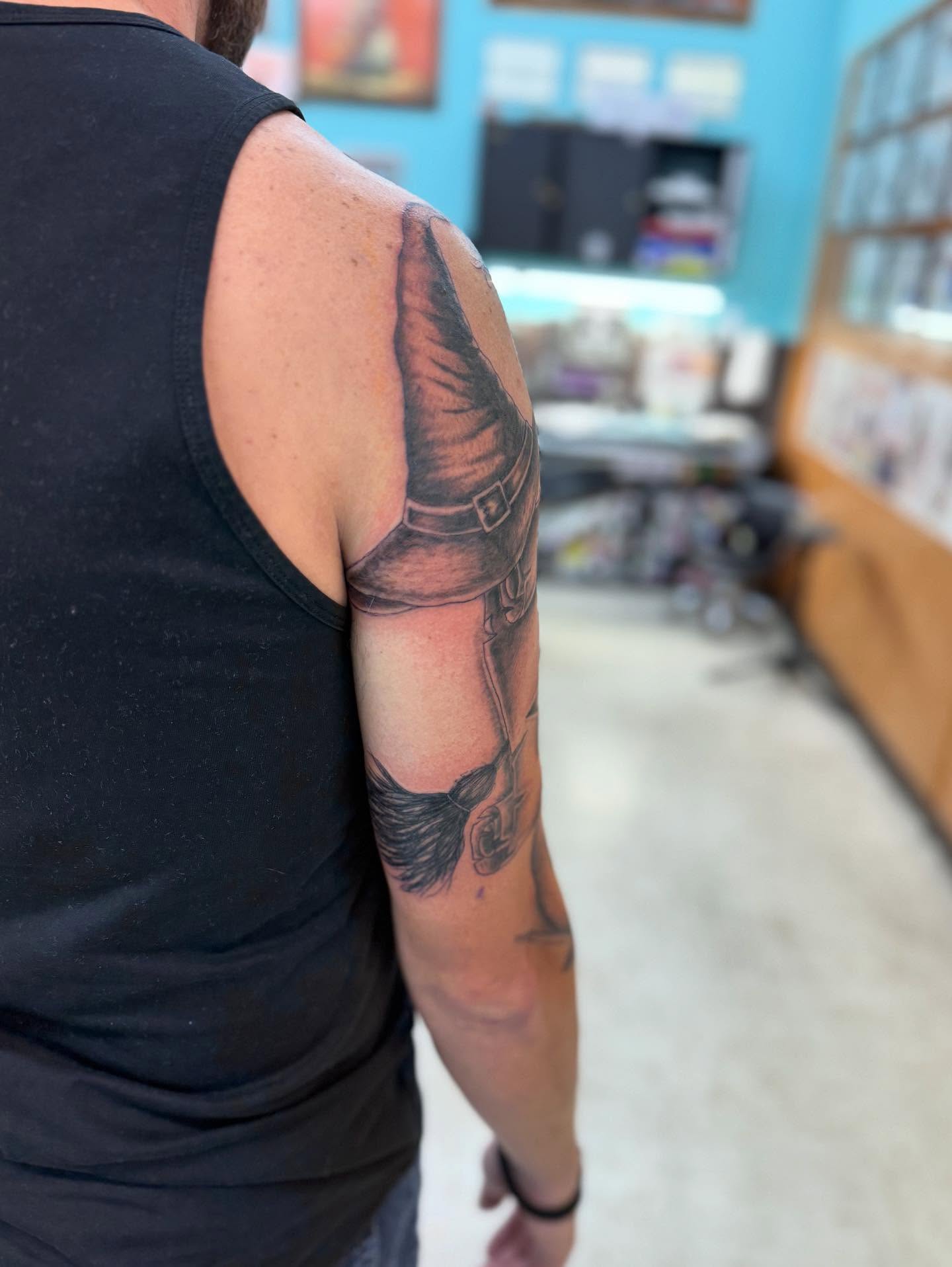 Wizard hat black and grey tattoo on the upper arm by Levi Sawdon, Everett, Washington
