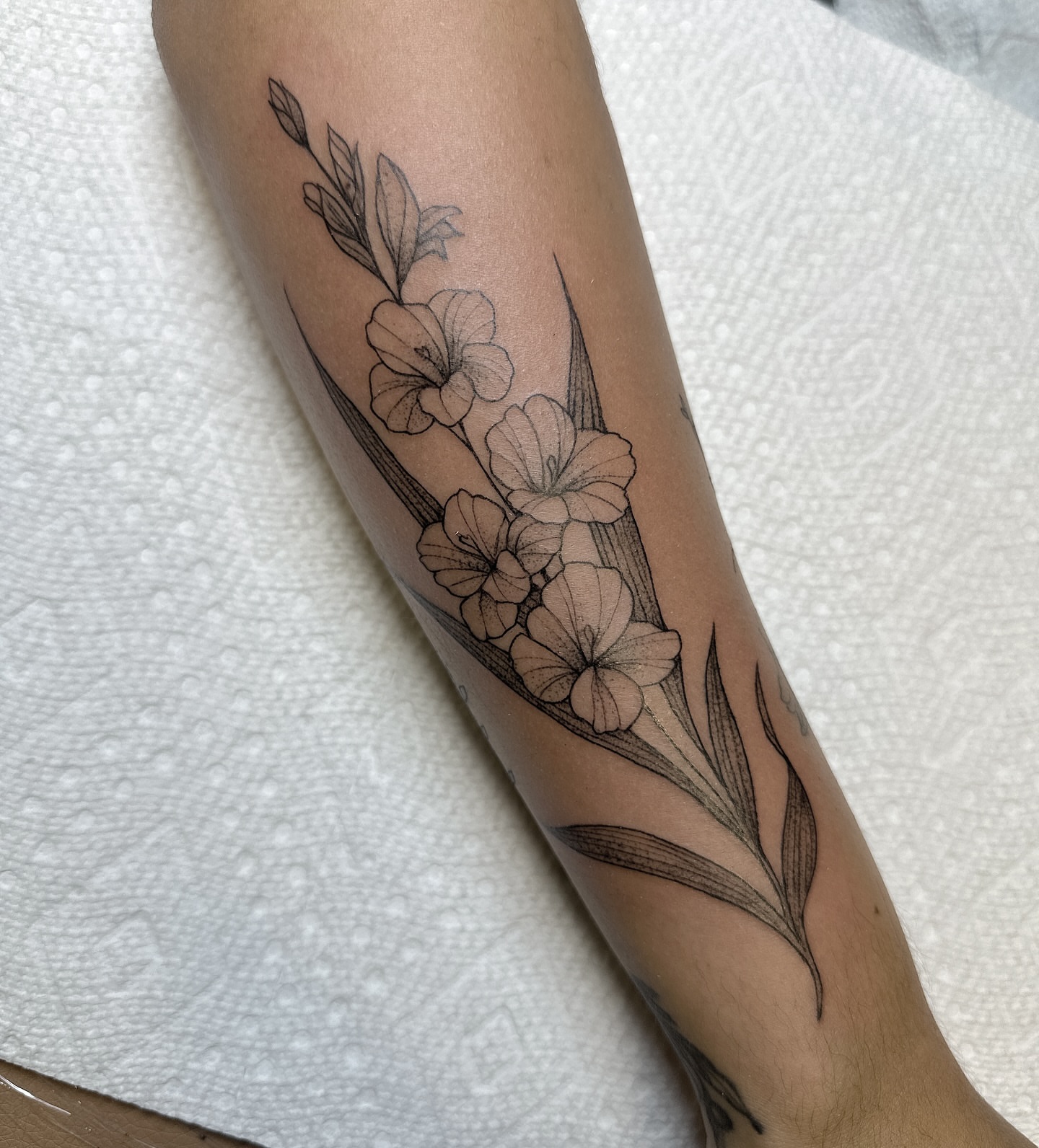 Flowers black and grey tattoo on the forearm by Robert McCollum
