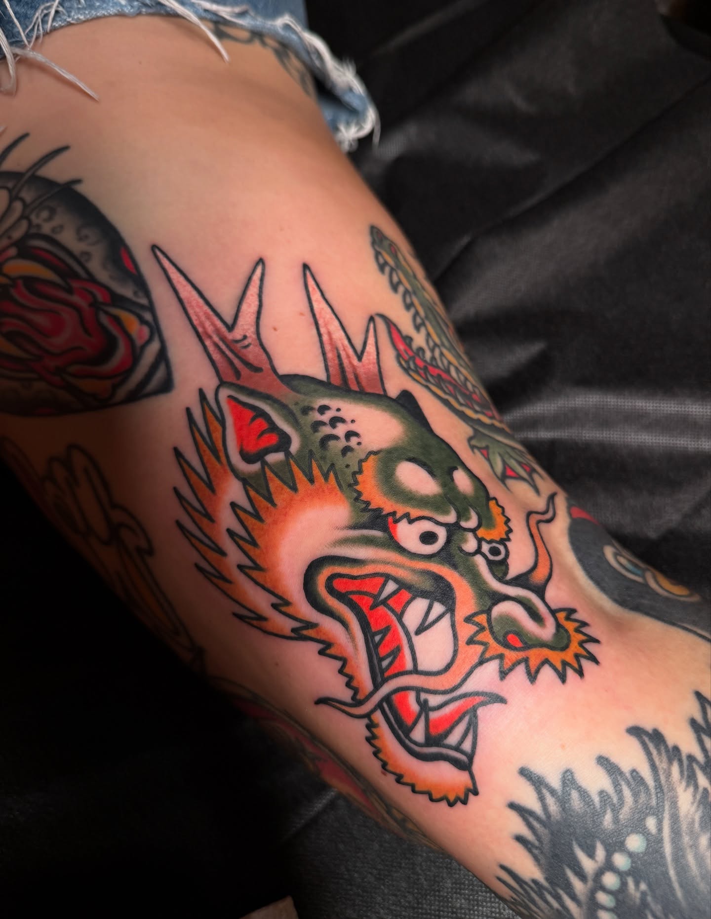 Dragon American traditional tattoo on the upper arm by Chaz Otto