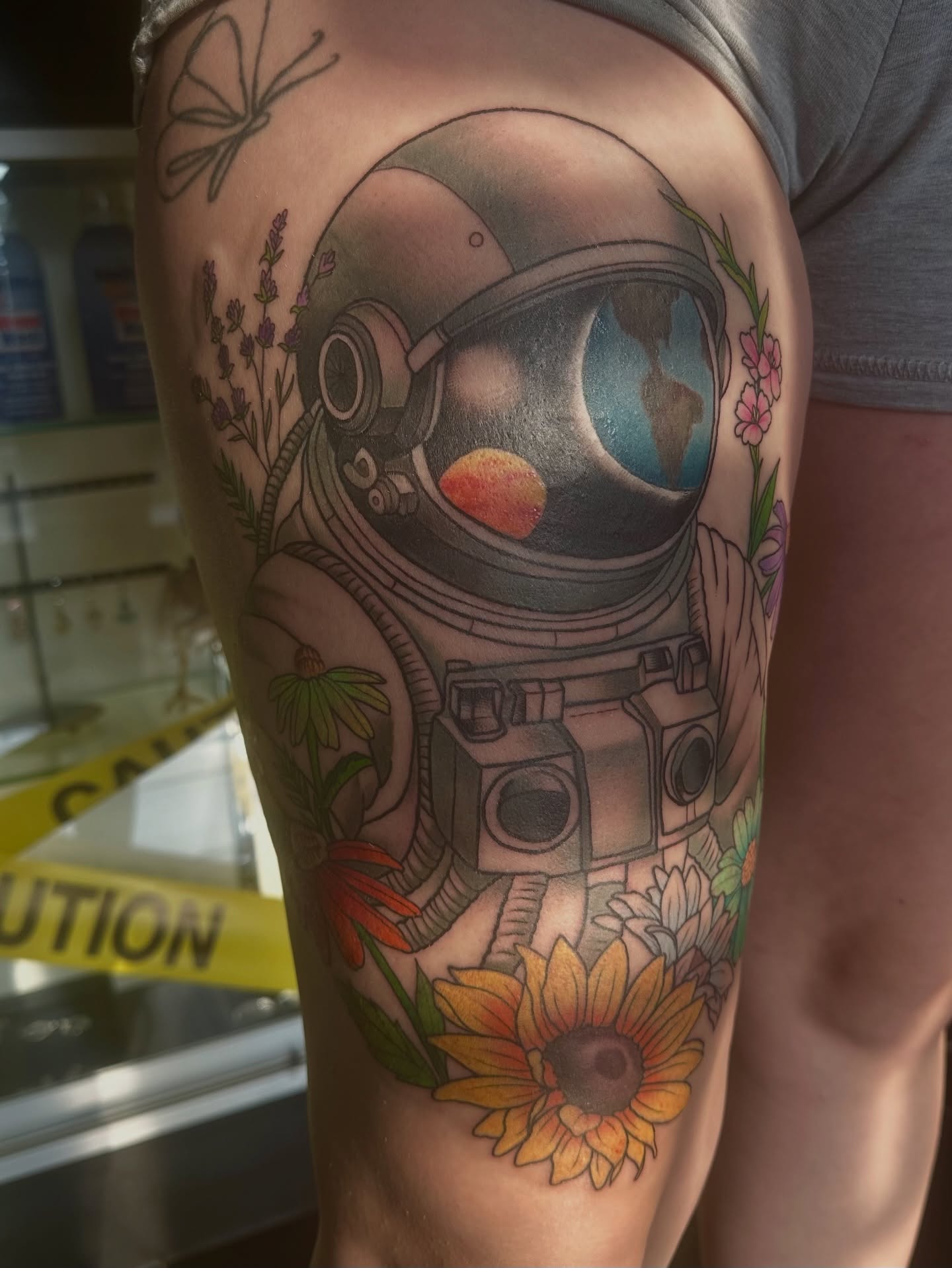 Astronaut with flowers realism tattoo on the thigh by Carly🪲 greensboro tattoo artist, Greensboro, North Carolina
