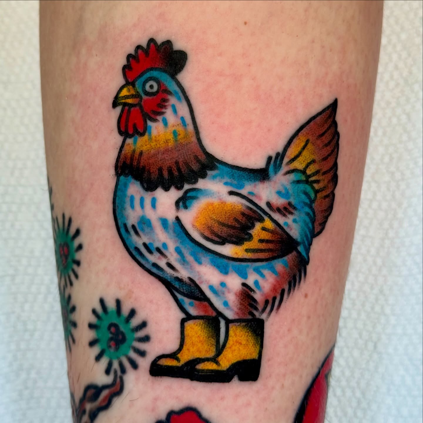 Rooster wearing boots American traditional tattoo on the forearm by Joe Bear Tattooer