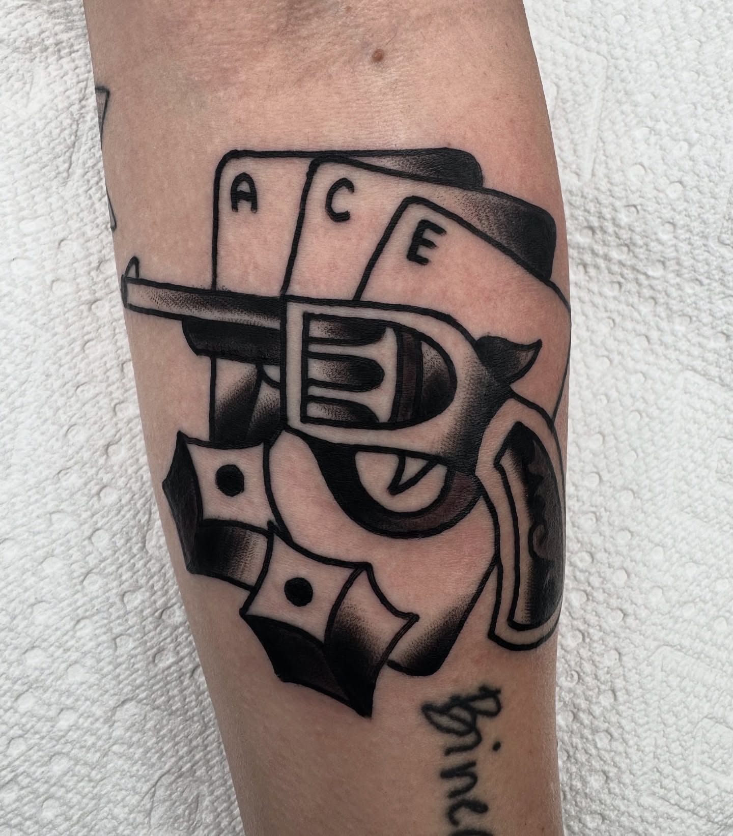 Playing card and gun American traditional tattoo on the forearm by Drew🕸️, Phoenix, Arizona