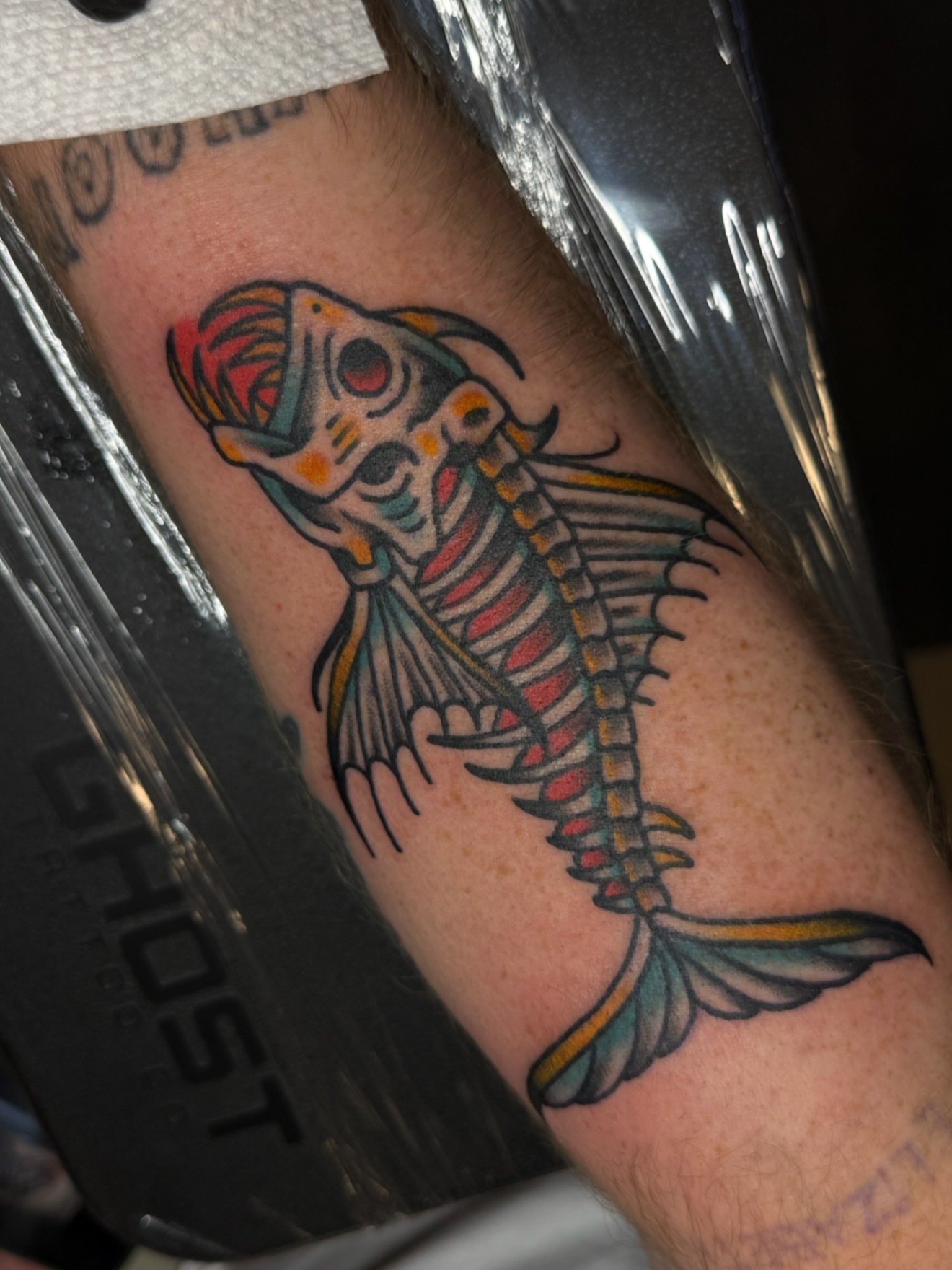 Fish skeleton American traditional tattoo on the forearm by Zac Clark