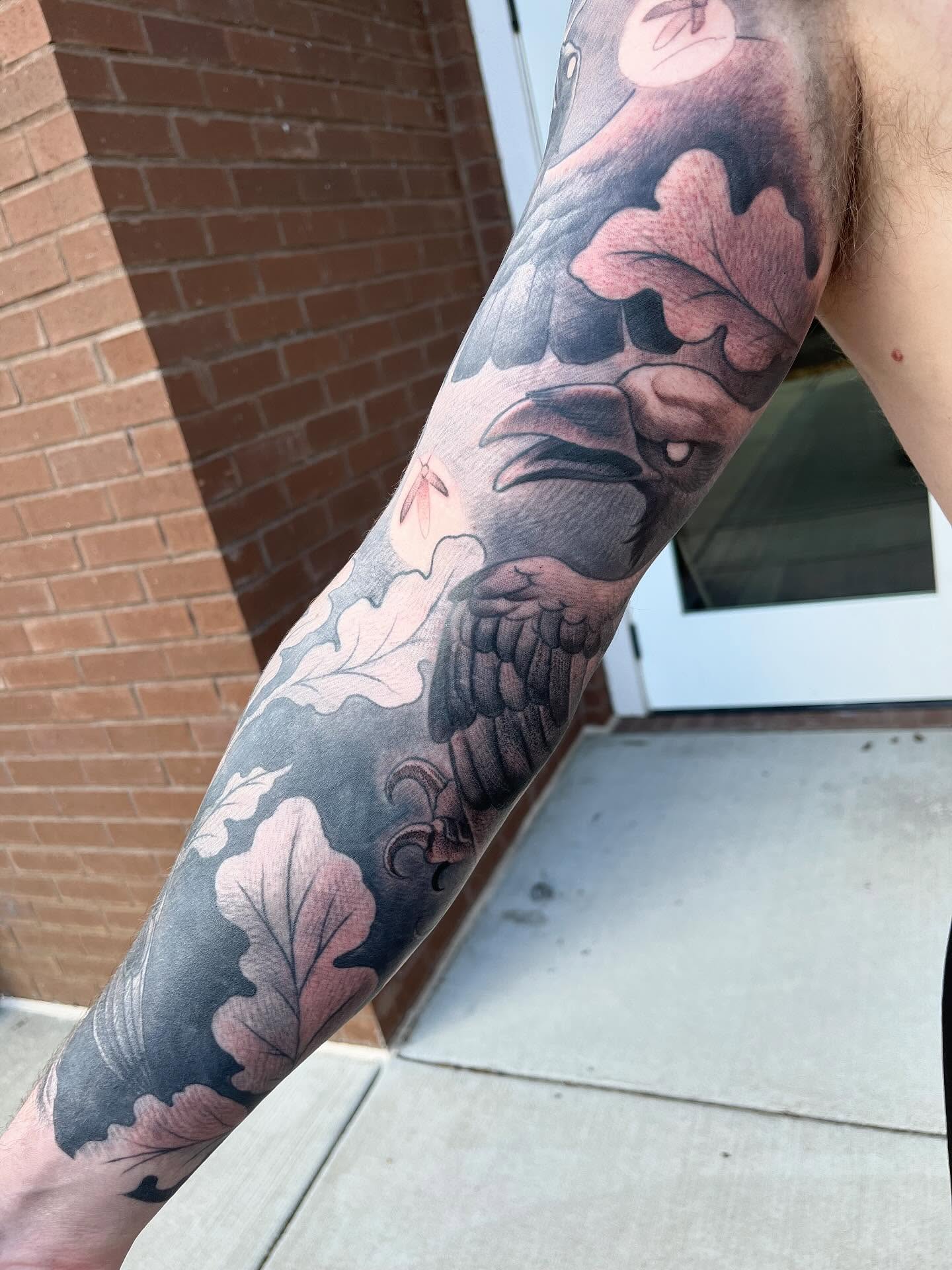 Bird and leaves black and grey tattoo on the forearm by Ian White