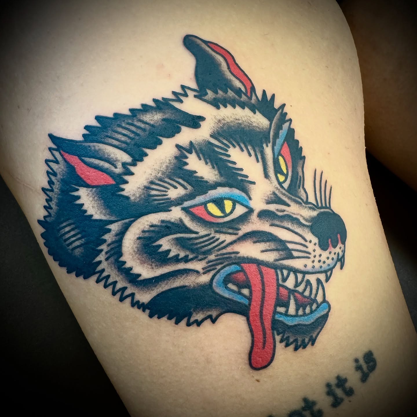 Wolf head American traditional tattoo on the thigh by Kristen