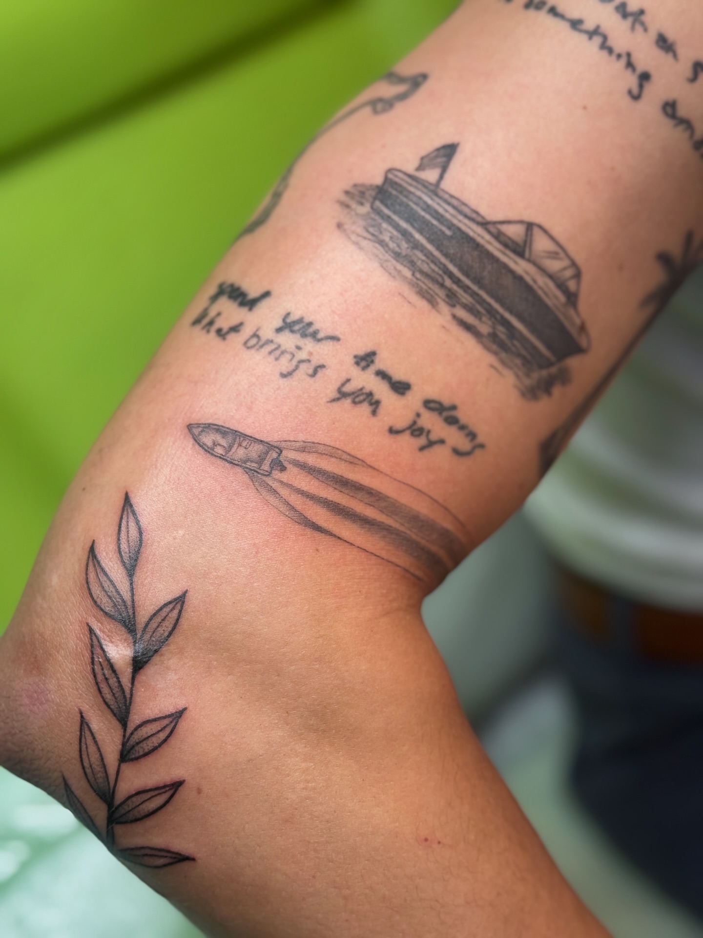 Cruise ship and quote black and grey tattoo on the forearm by Lily Bejarno