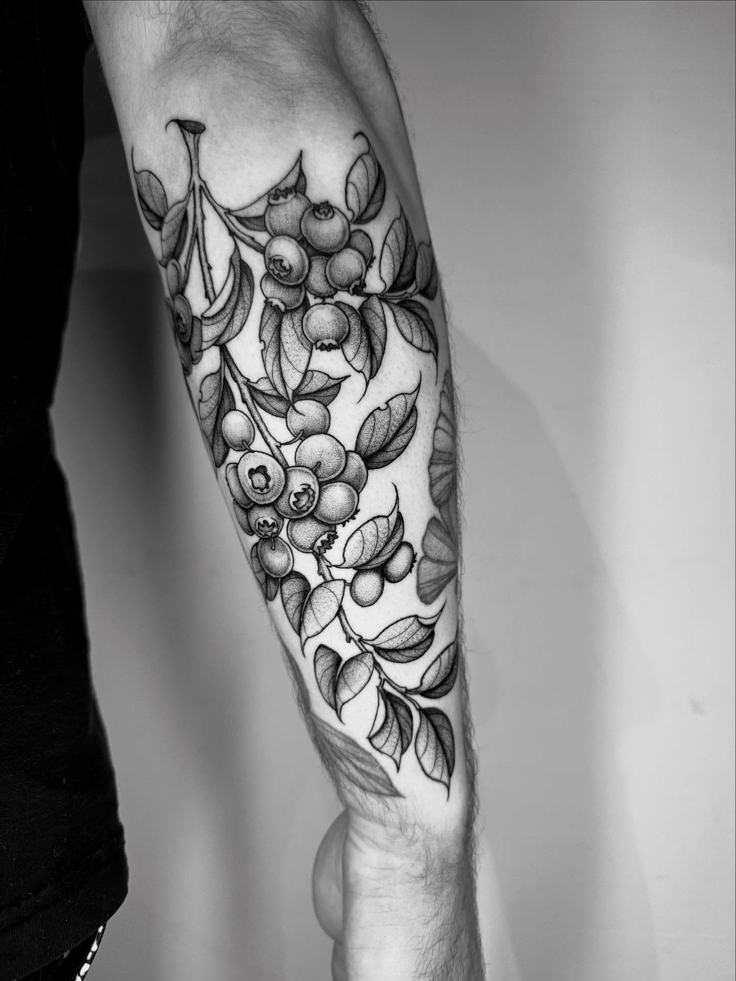 Blueberries and leaves dotwork tattoo on the forearm by Lauren Llerandi