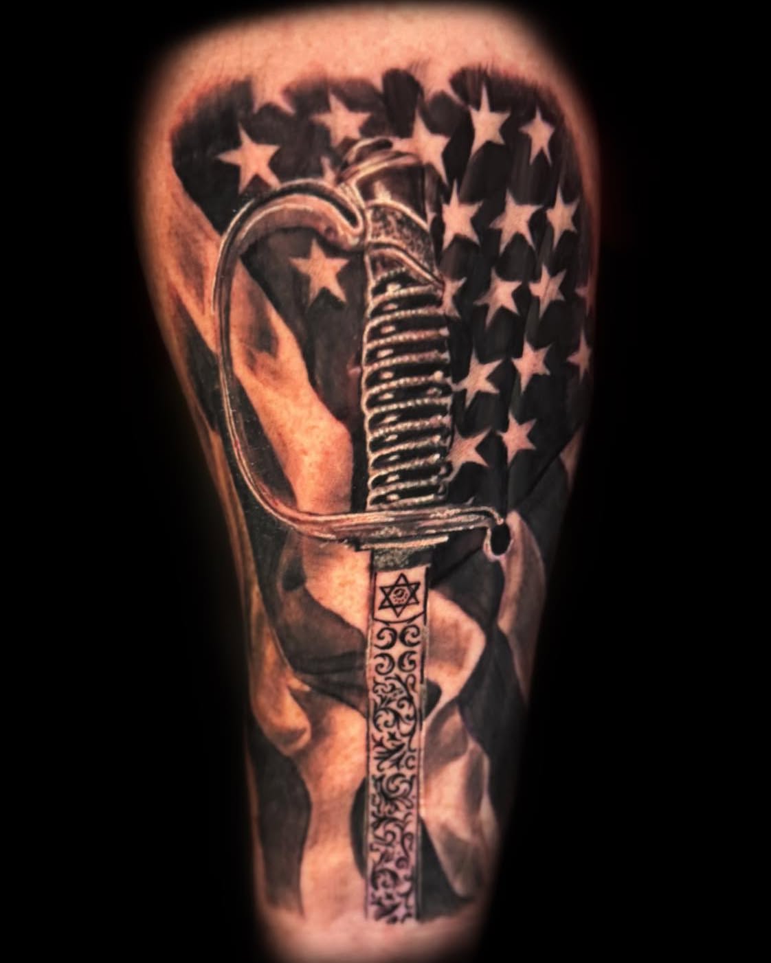 Sword and American flag American traditional tattoo on the forearm by Bobby Hurst