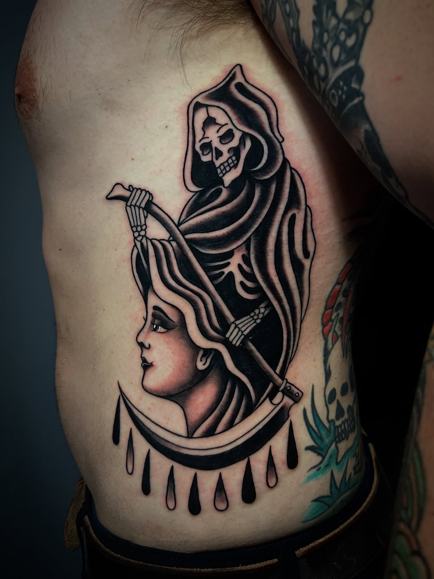 Reaper and woman American traditional tattoo on the ribs by Michael Munter, Philadelphia, Pennsylvania