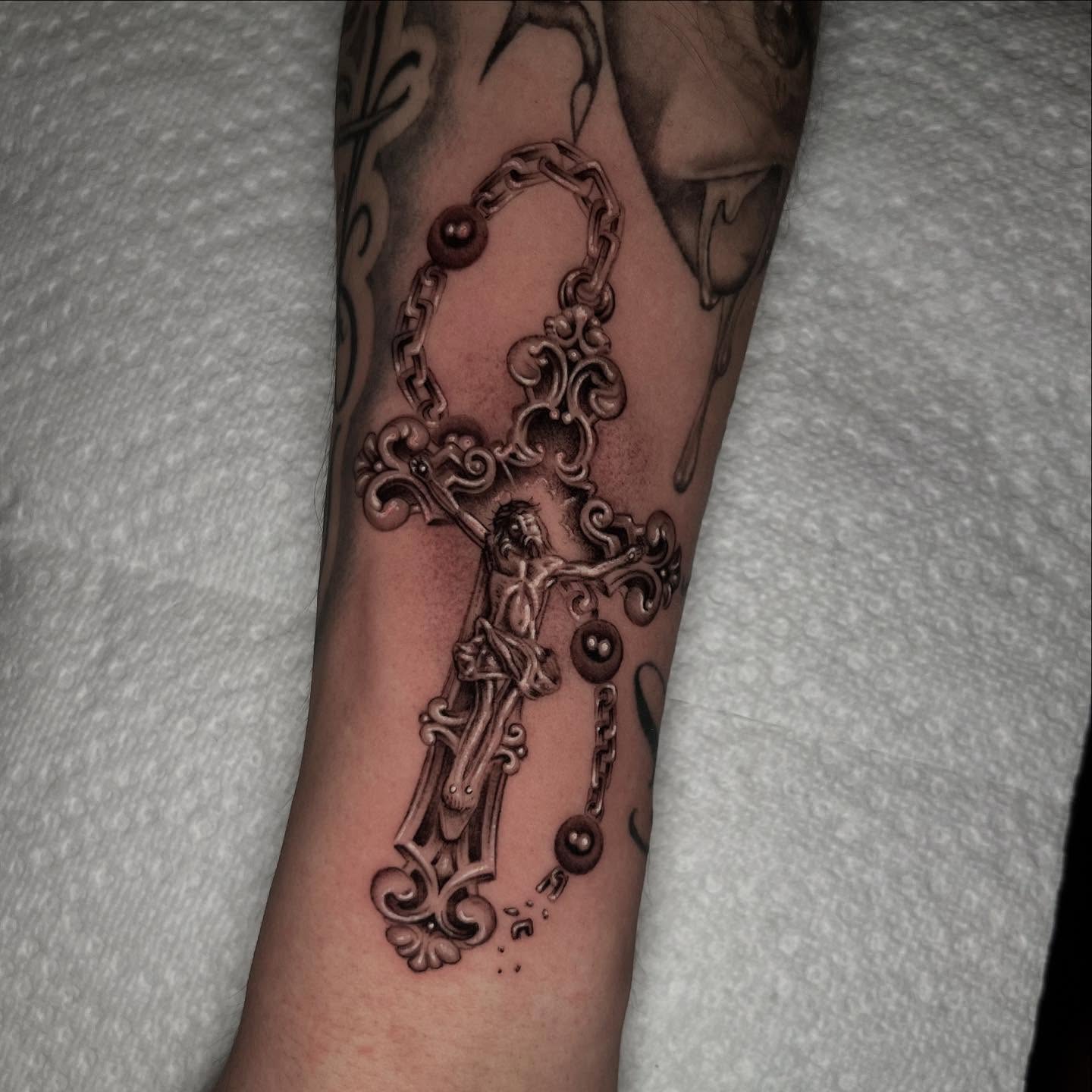 Cross with chains ornamental tattoo on the forearm by Single Needle ๐ชฉ