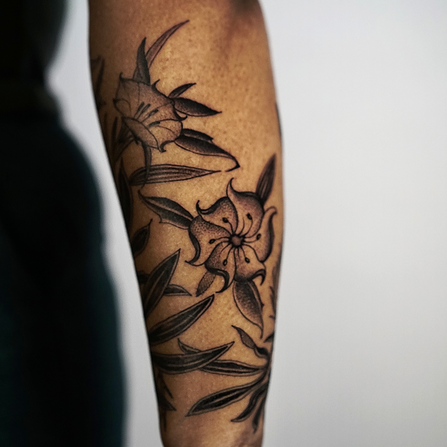 Lily flowers black and grey tattoo on the forearm by H I R A  L U P E - tattoo artist, Oakland, California
