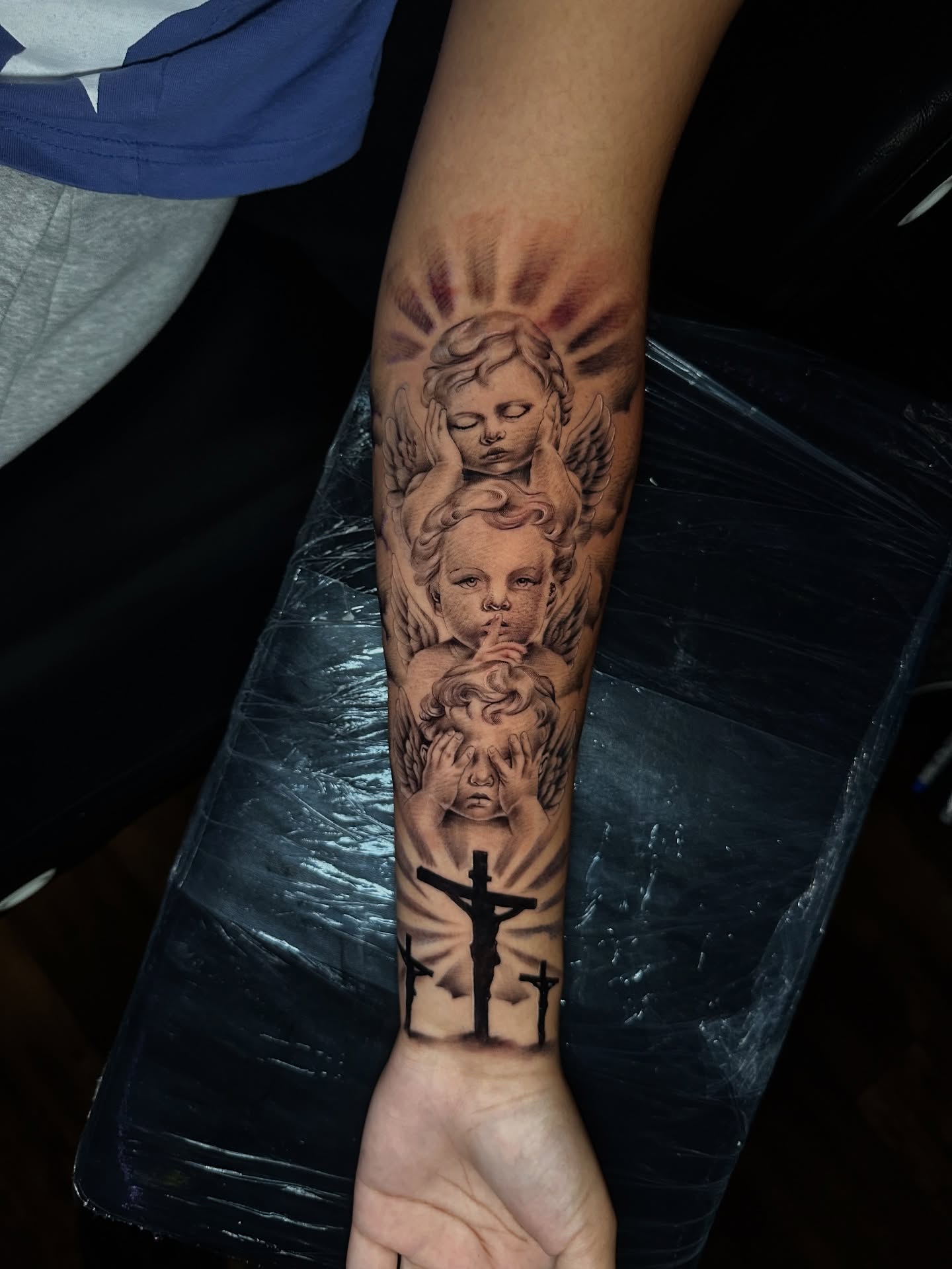 Angels and cross black and grey tattoo on the forearm by Chris (Pikasso)