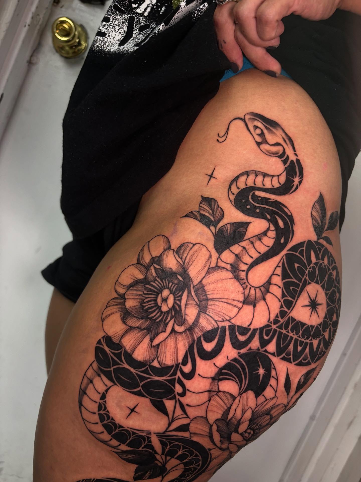 Snake and peony black and grey tattoo on the thigh by Tattoos by Tessa