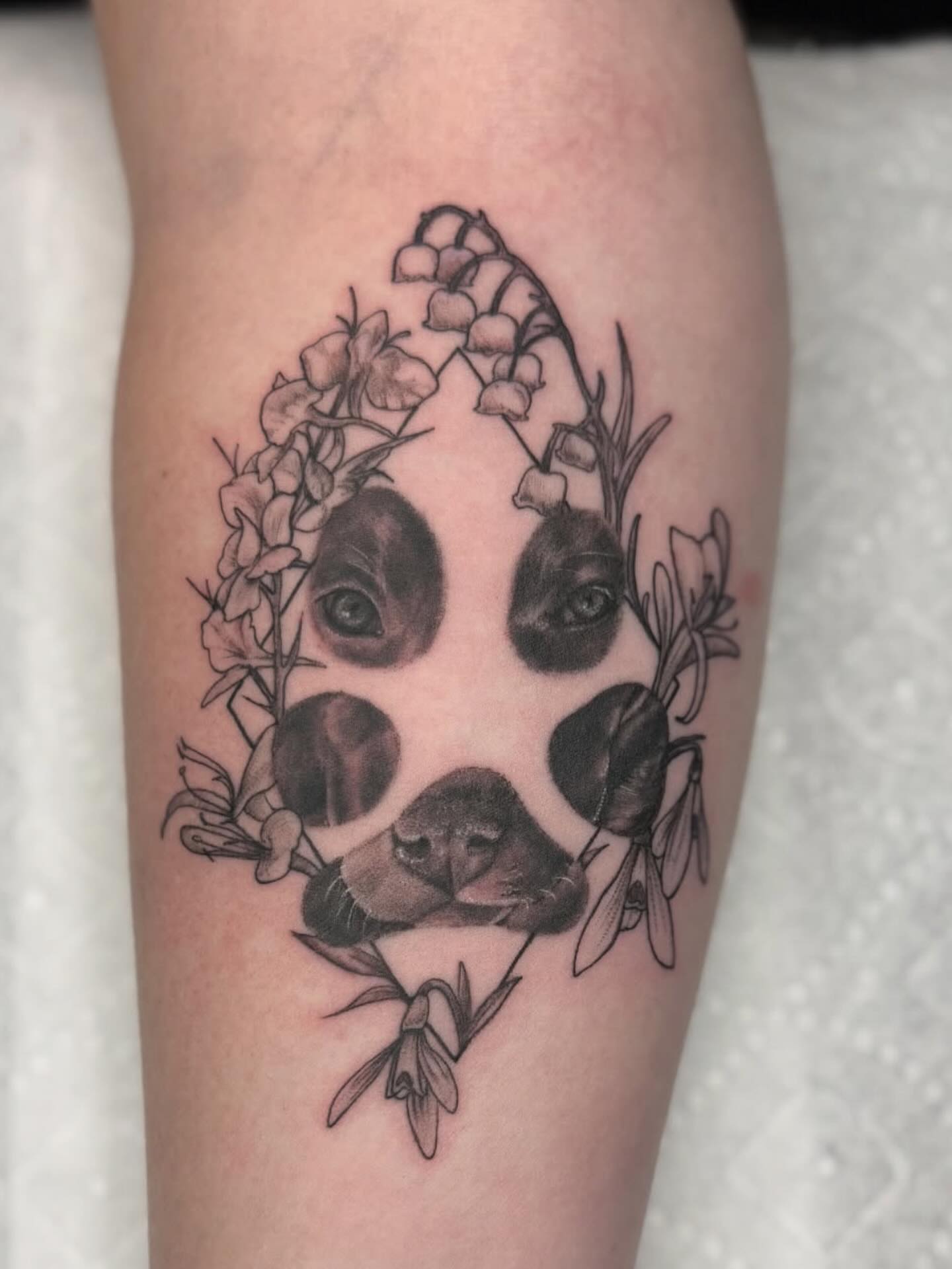 Panda head with flowers realism tattoo on the forearm by Kelsey Kemp