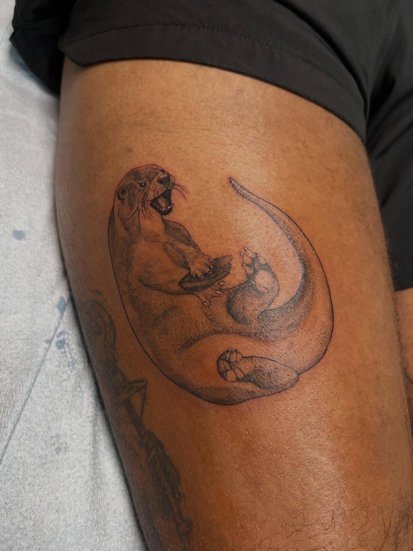 Sea otter black and grey tattoo on the thigh by sarah bug