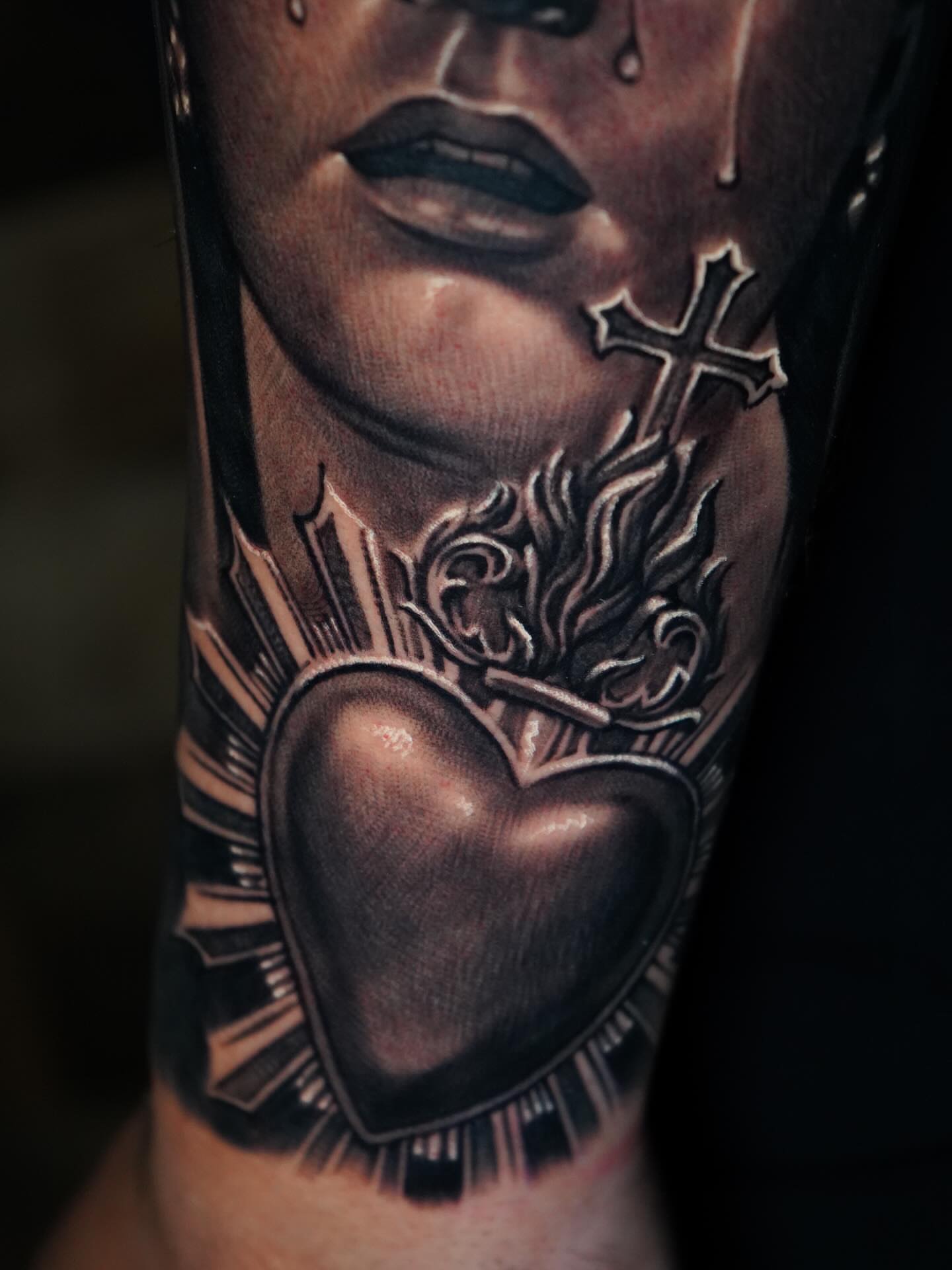 Heart with cross and flames realism tattoo on the forearm by Edgar Campaña
