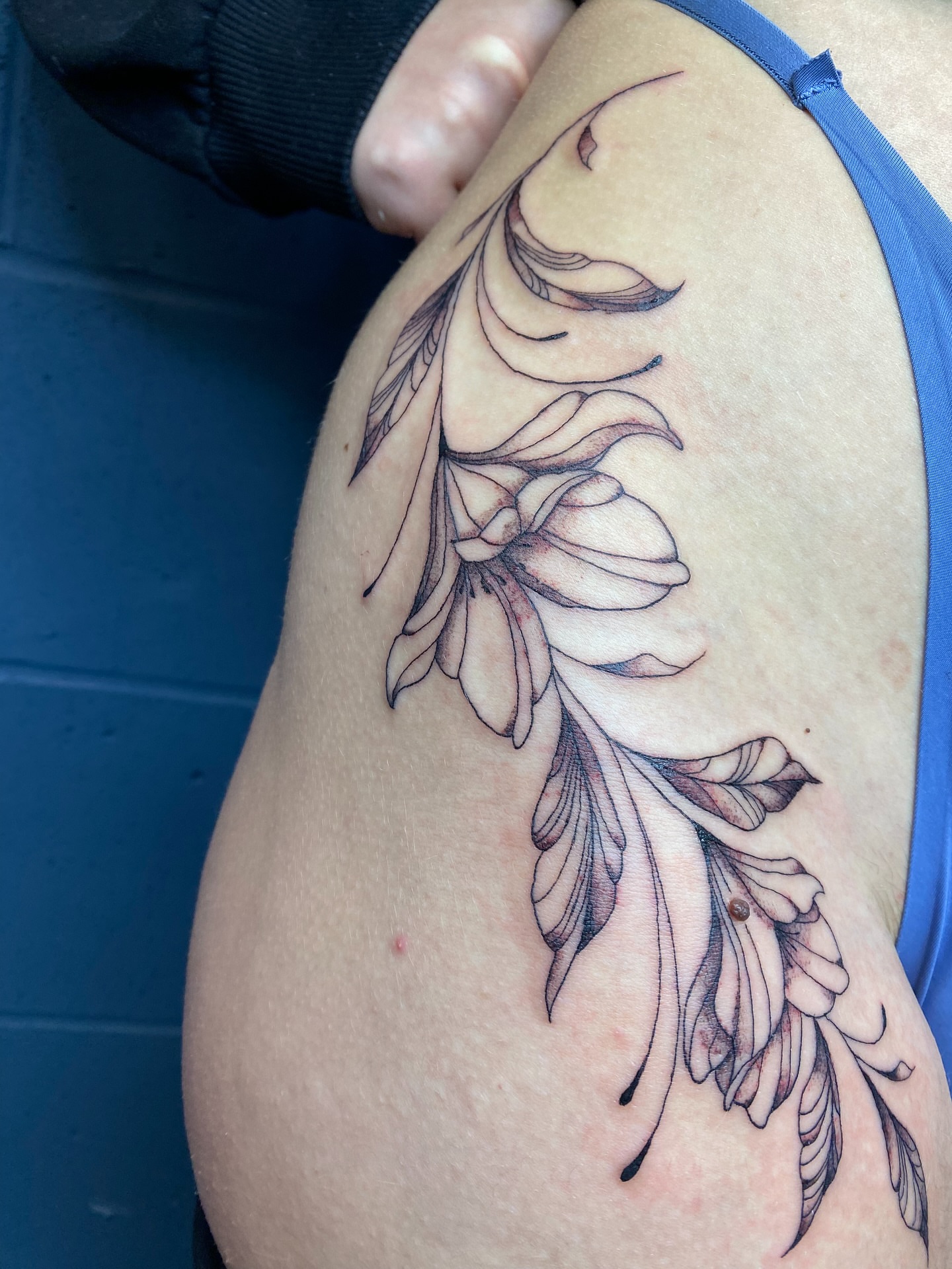 Floral black and grey tattoo on the thigh by Ellena Reggiani