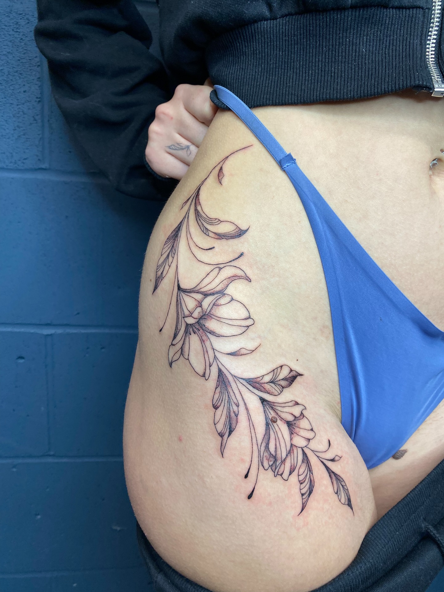 Floral branch black and grey tattoo on the thigh by Ellena Reggiani