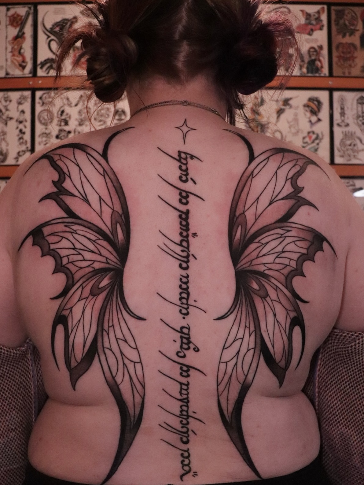 Wings and script geometric tattoo on the back by Dylan Mott