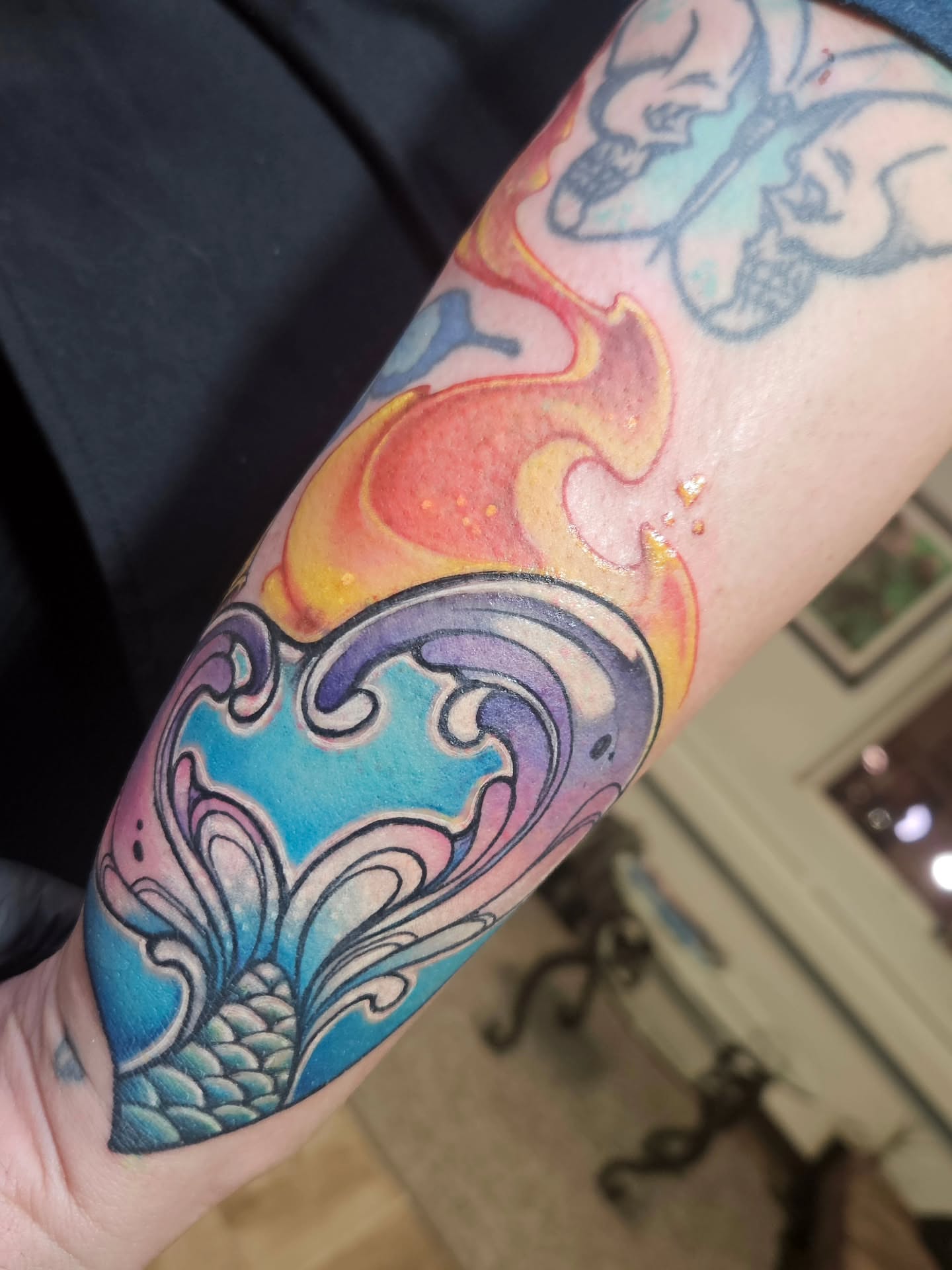 Flame and wave watercolor tattoo on the forearm by Angell Tattoo Artist, Denver, Colorado