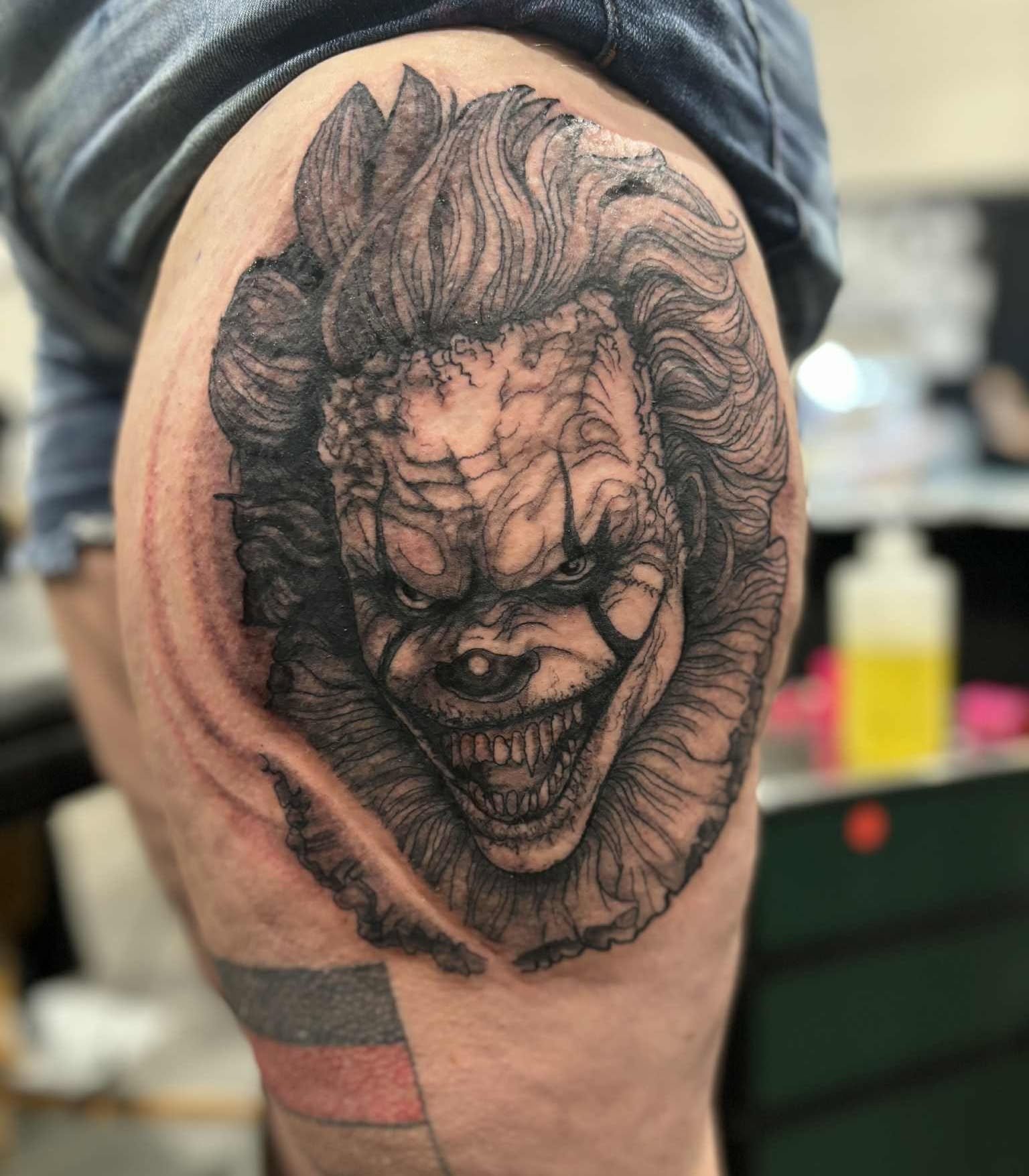 Creepy clown portrait realism tattoo on the thigh by Russell Lucas