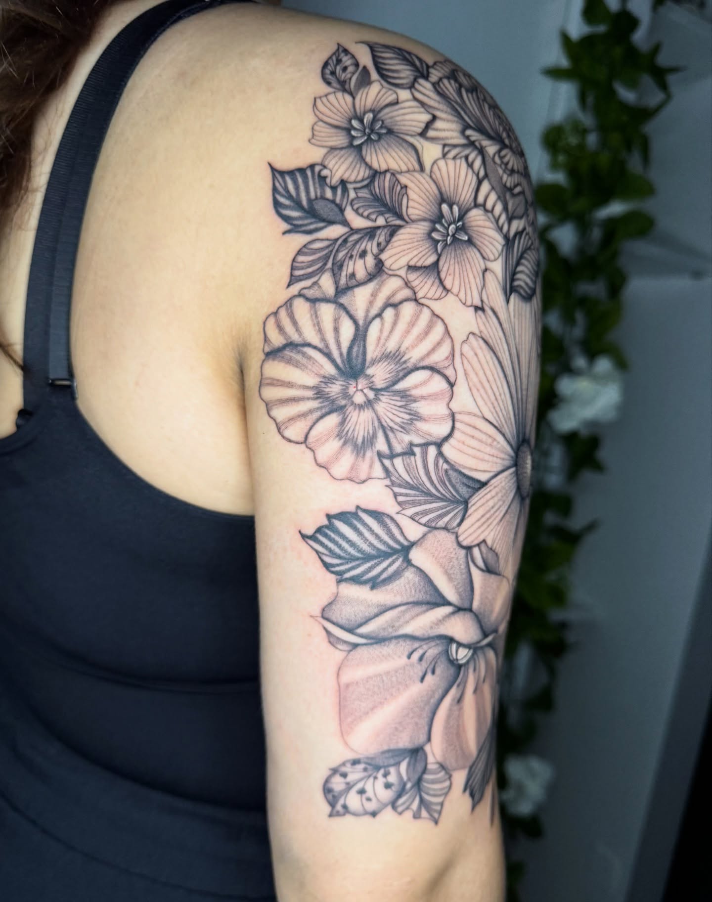 Floral bouquet black and grey tattoo on the upper arm by Austin Tattoo Artist, Austin, Texas