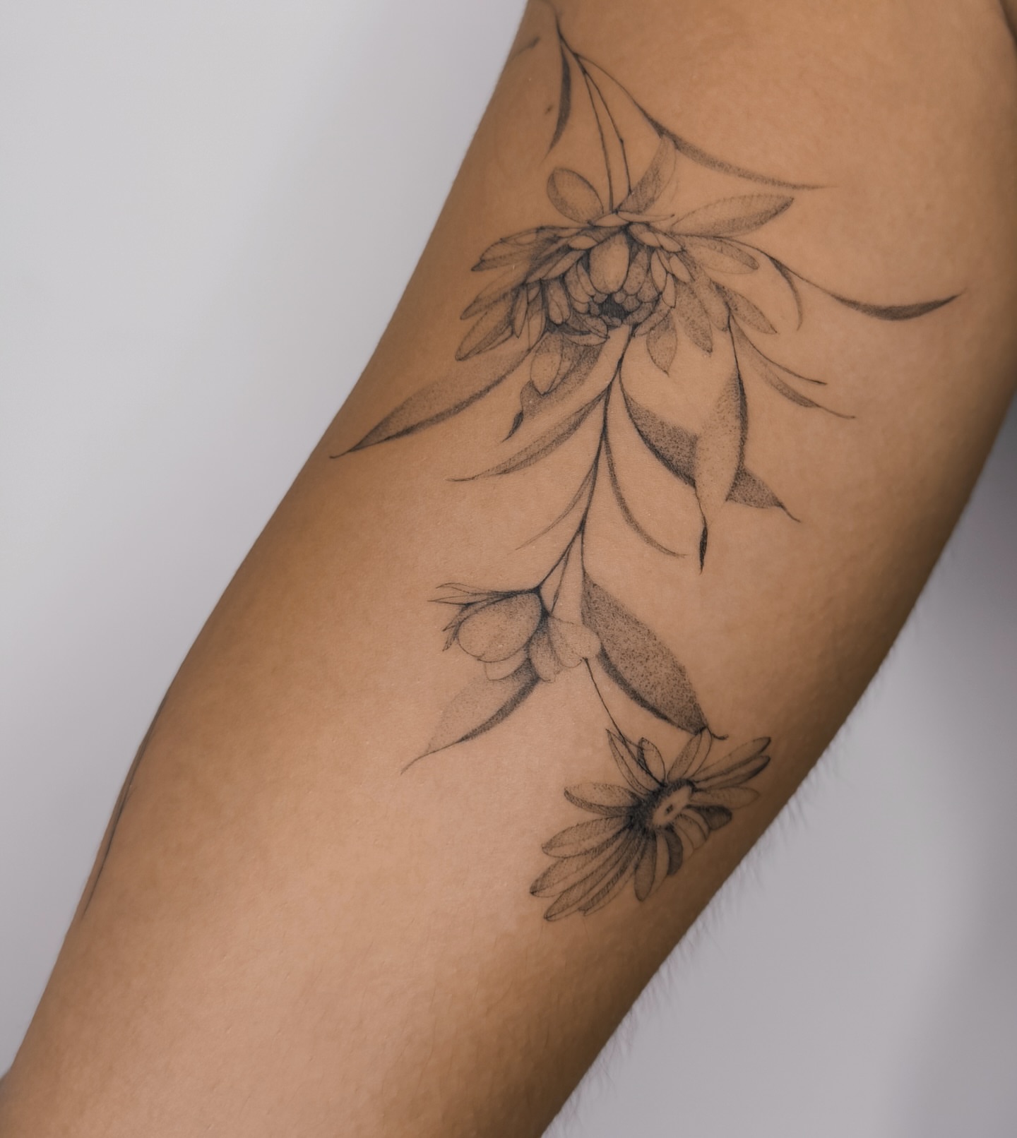 Floral arrangement black and grey tattoo on the forearm by Blackwork & microrealism tattoos