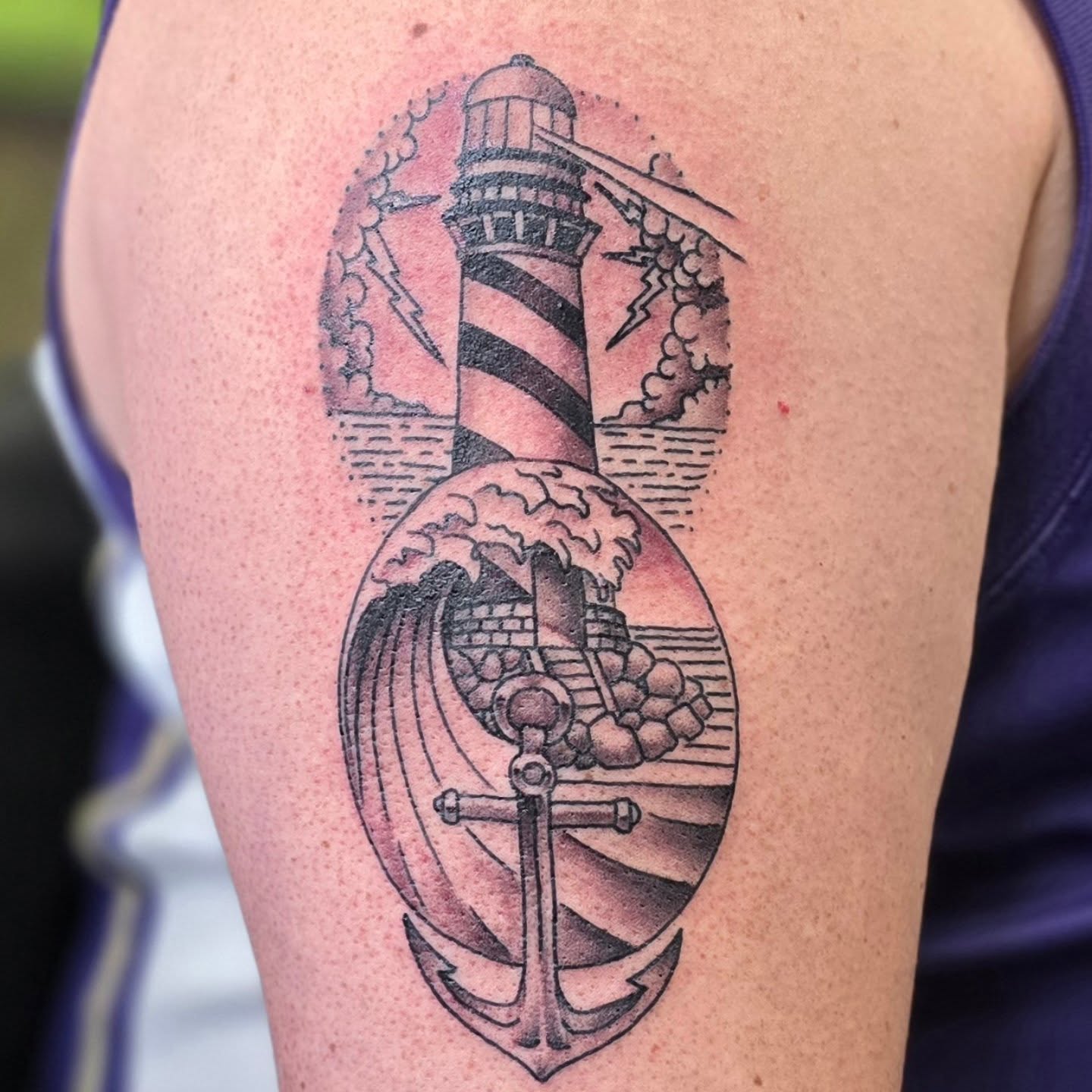 Lighthouse and anchor black and grey tattoo on the upper arm by Steve Atkinson Tattoo Artist