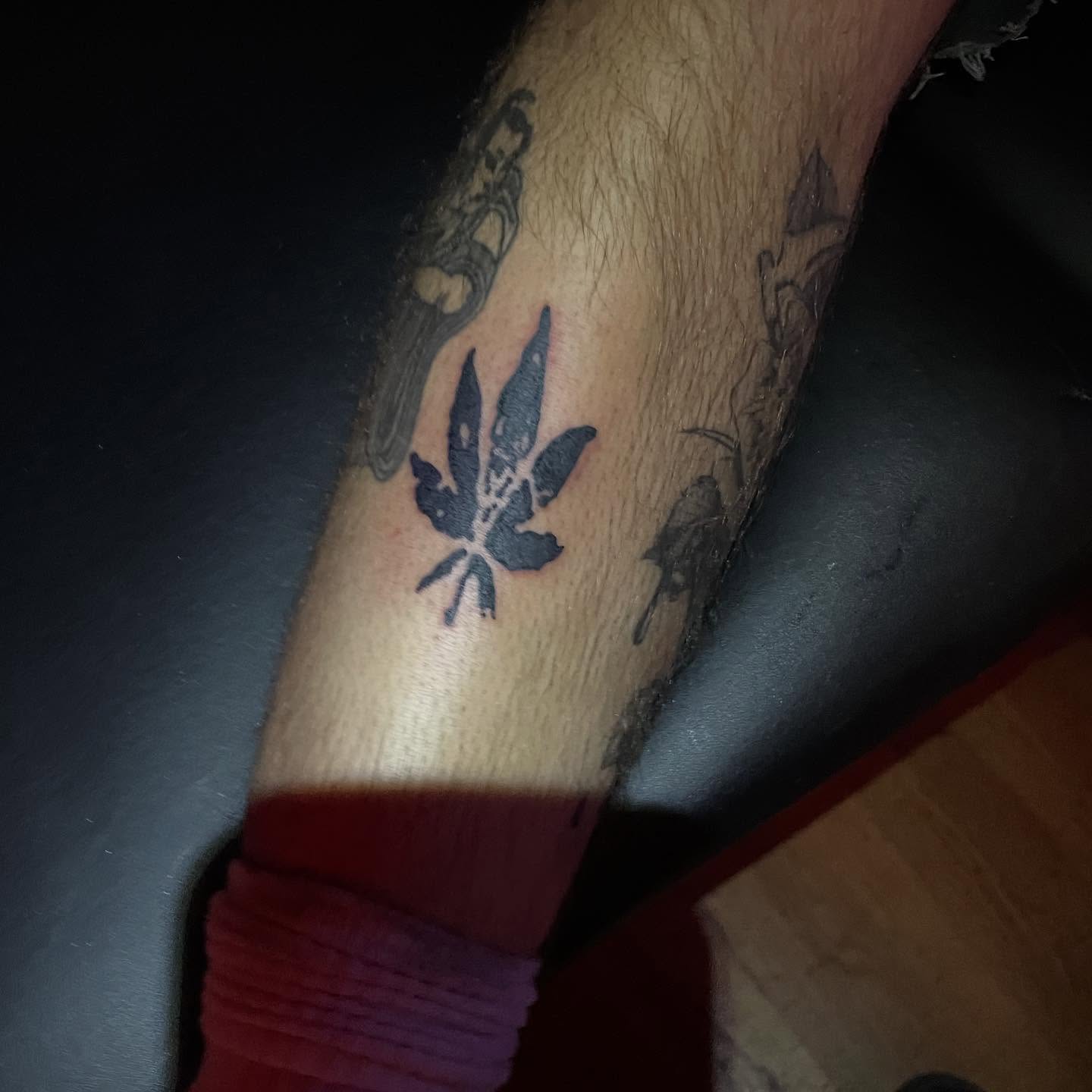 Marijuana leaf black and grey tattoo on the forearm by @emotionalthugtattoo