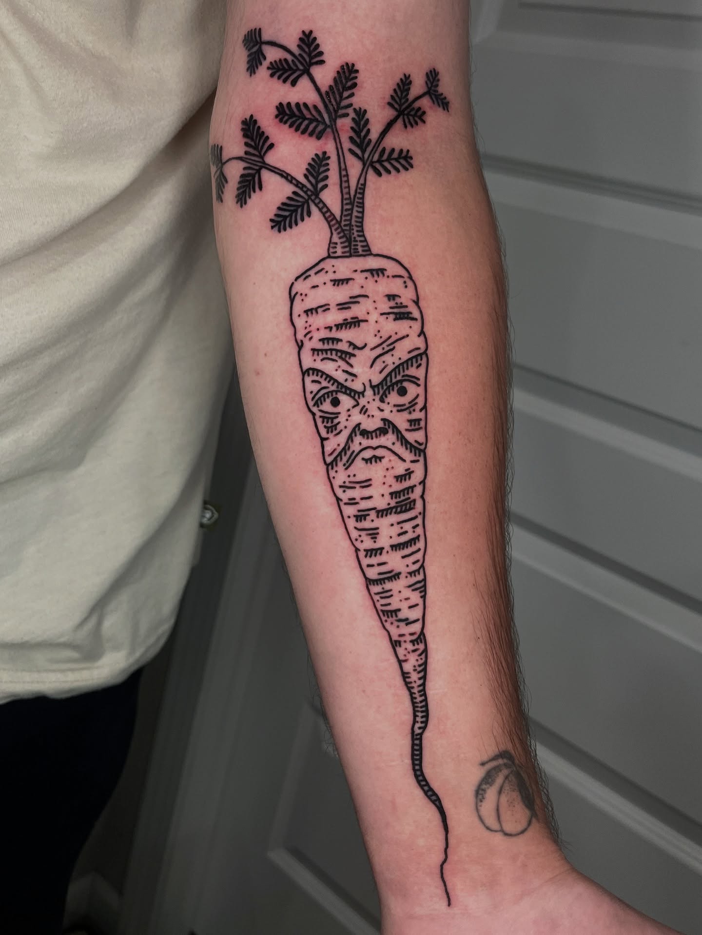 Carrot black and grey tattoo on the forearm by layne